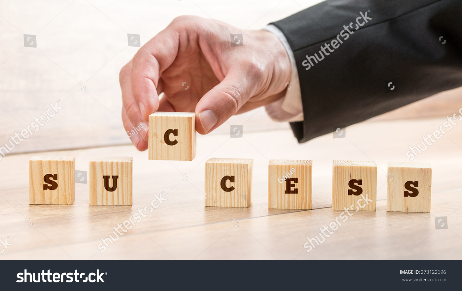 Close up Hand of a Businessman Arranging Small Wooden Blocks on the Table for Success Concept.