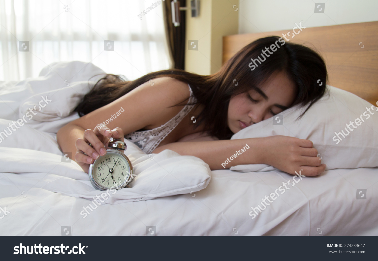 Woman turning off the alarm clock
