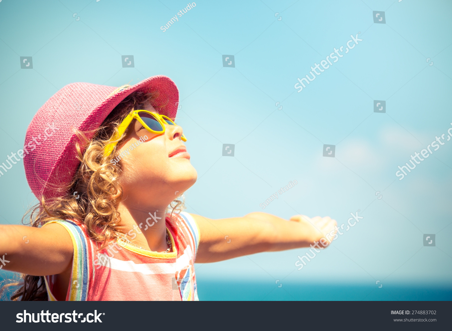 Happy child against blue sky background. Summer vacation concept