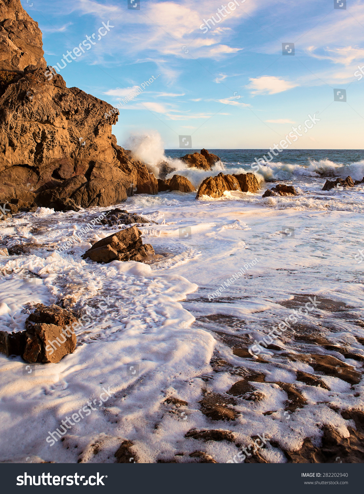 vertical image of water crashing on rocks