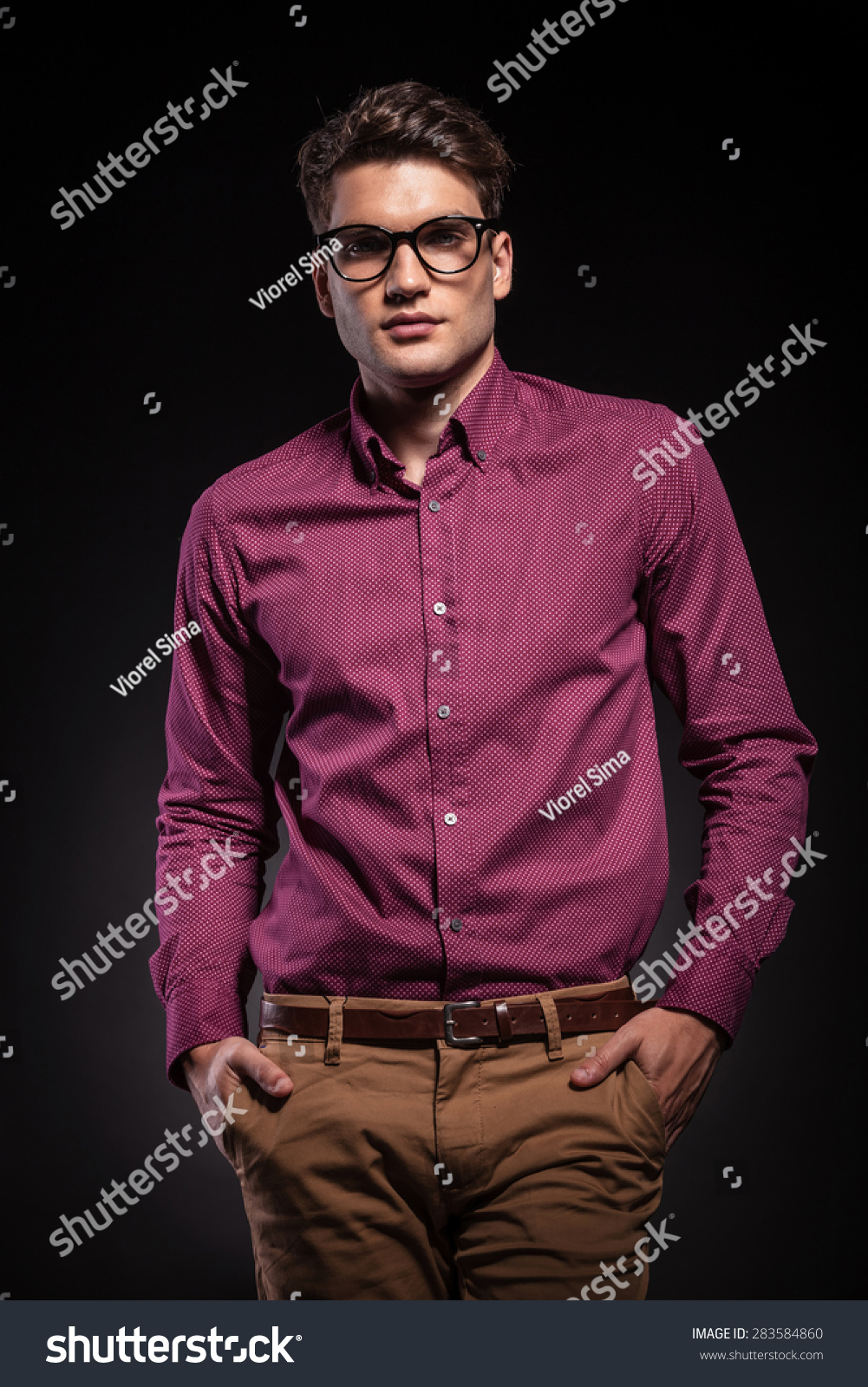 man looking at the camera while holding his hands in pockets