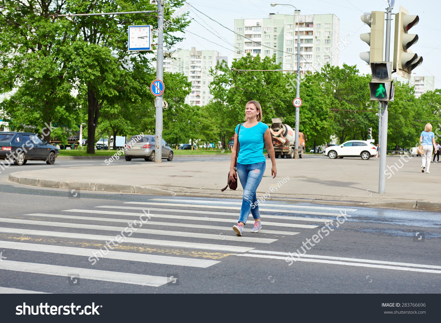 Young woman crossing the road at the green light