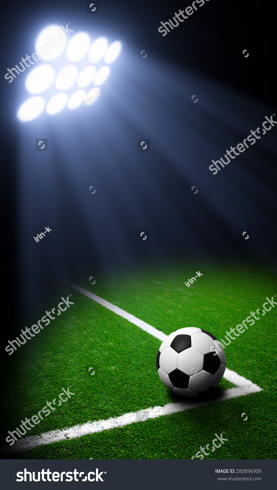 Soccer ball on green stadium  arena in night illuminated bright spotlights