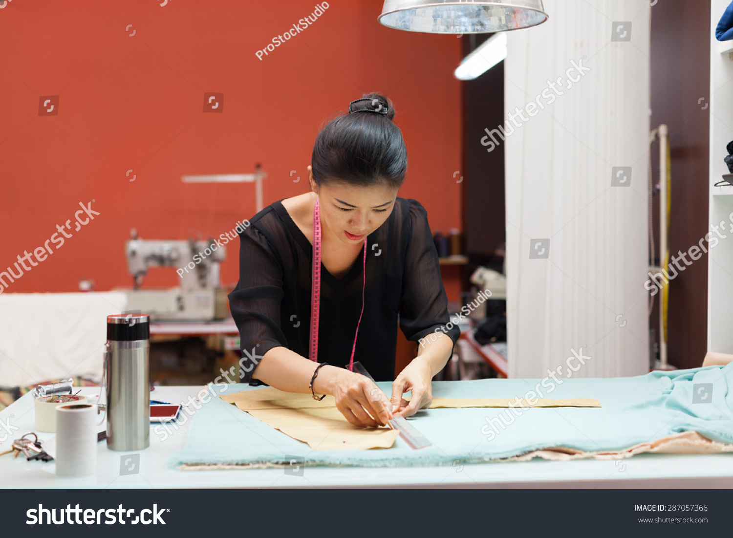 Asian woman tailor fashion clothes dress designer working with fabric on table