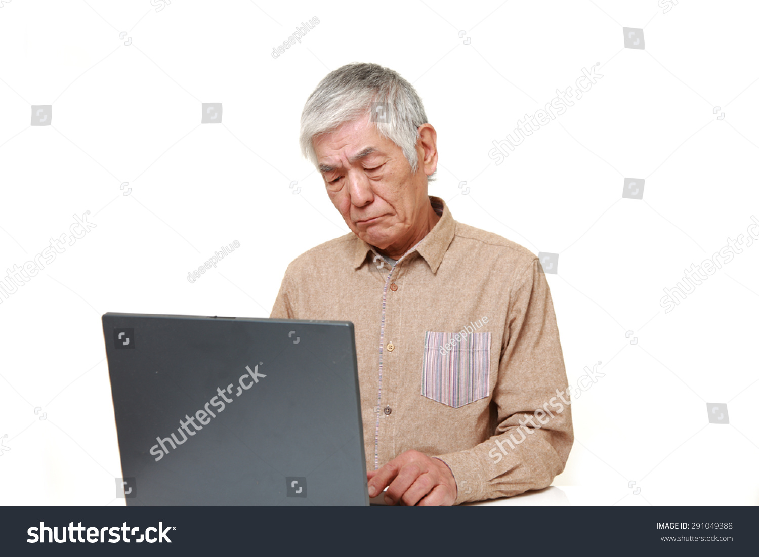 senior Japanese man using computer looking confused