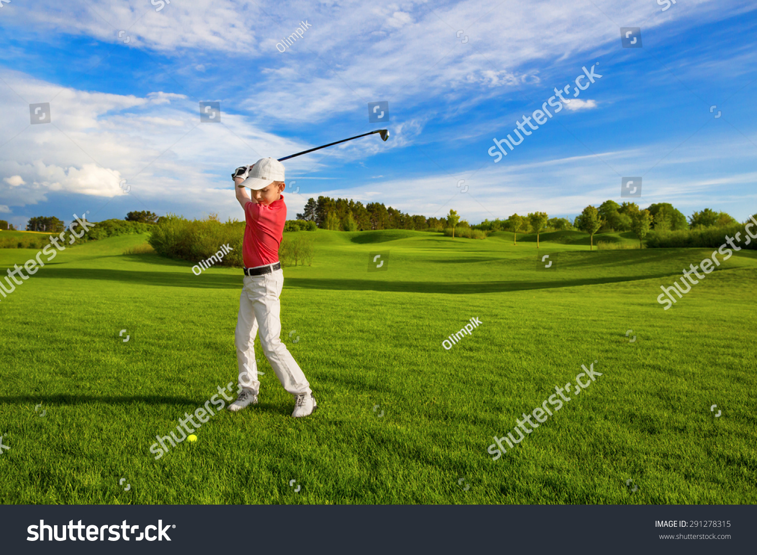 Boy golf player hitting by iron from fairway