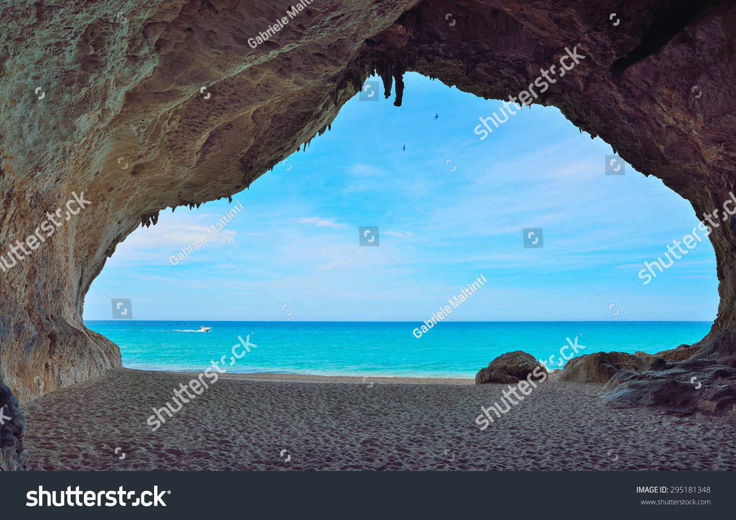 motorboat passing by a big cave in Cala Luna  Sardinia