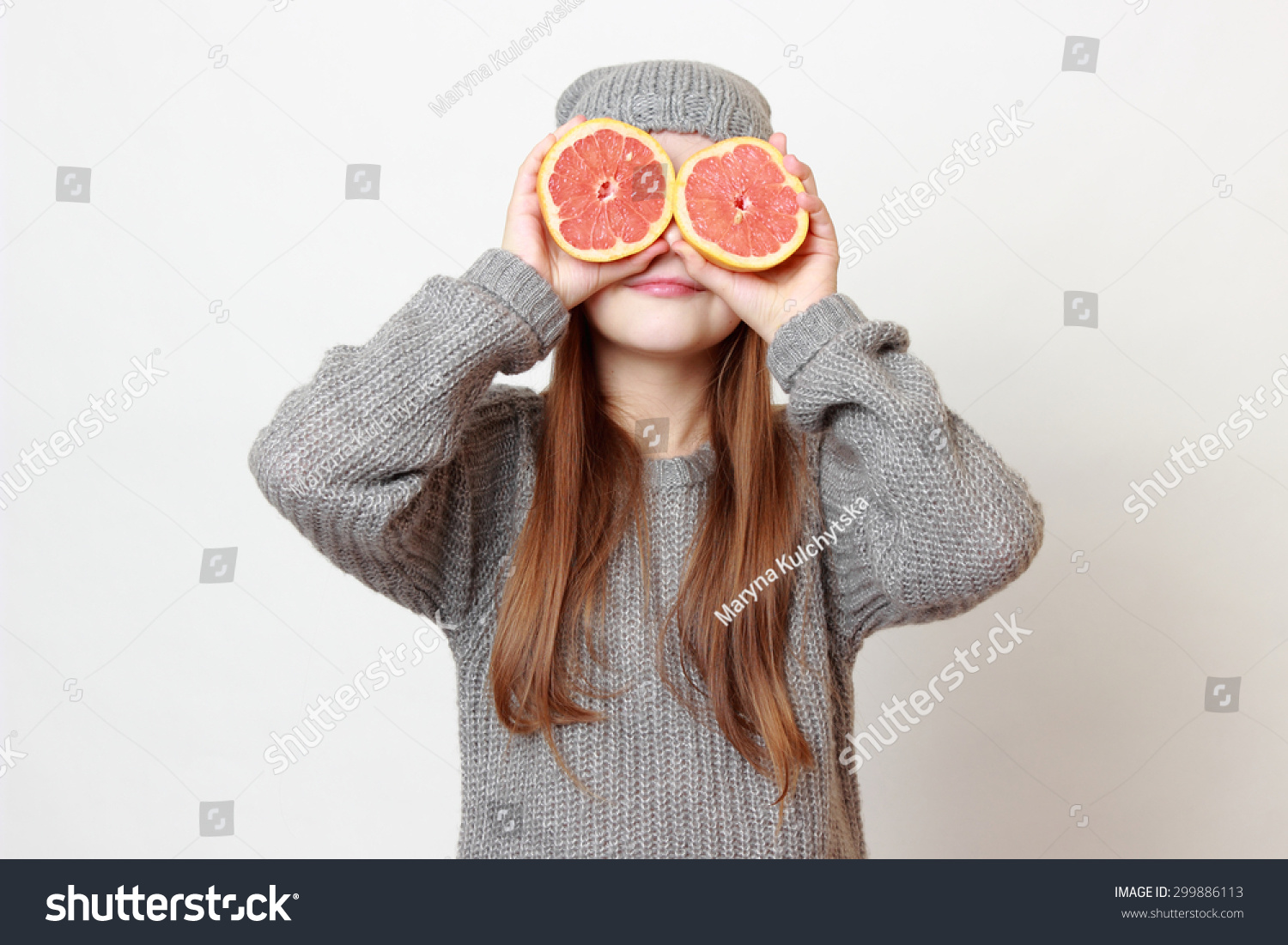 Fashion little girl holding grapefruit