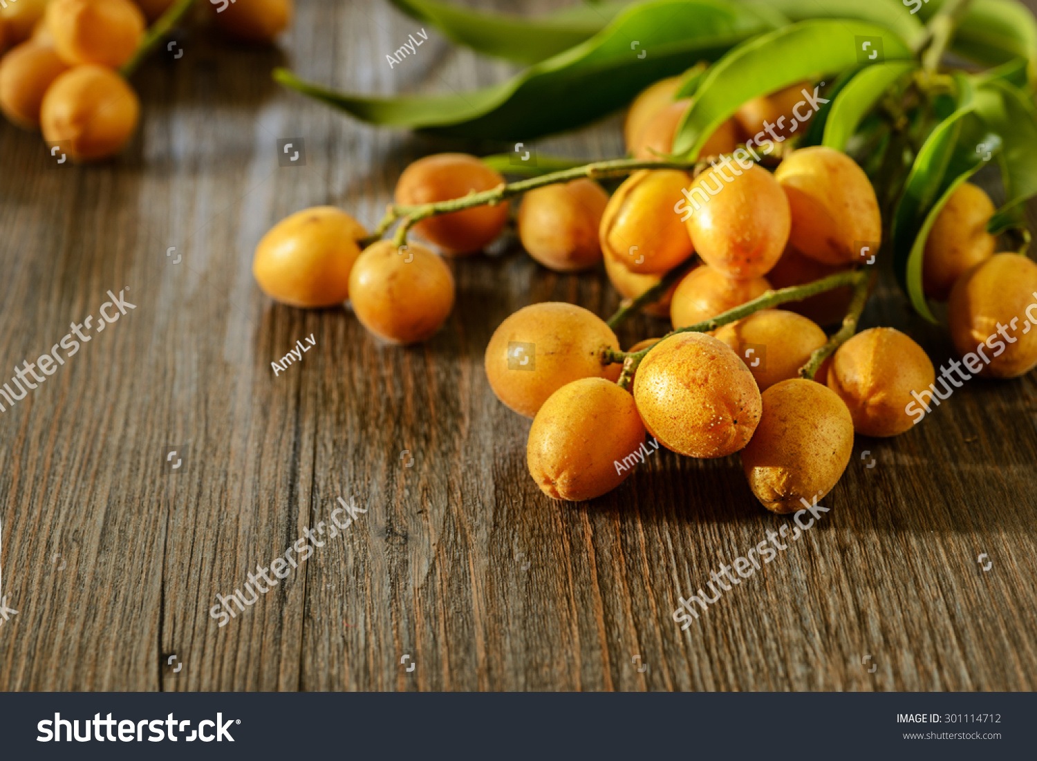 fresh wampee fruit on the wooden board