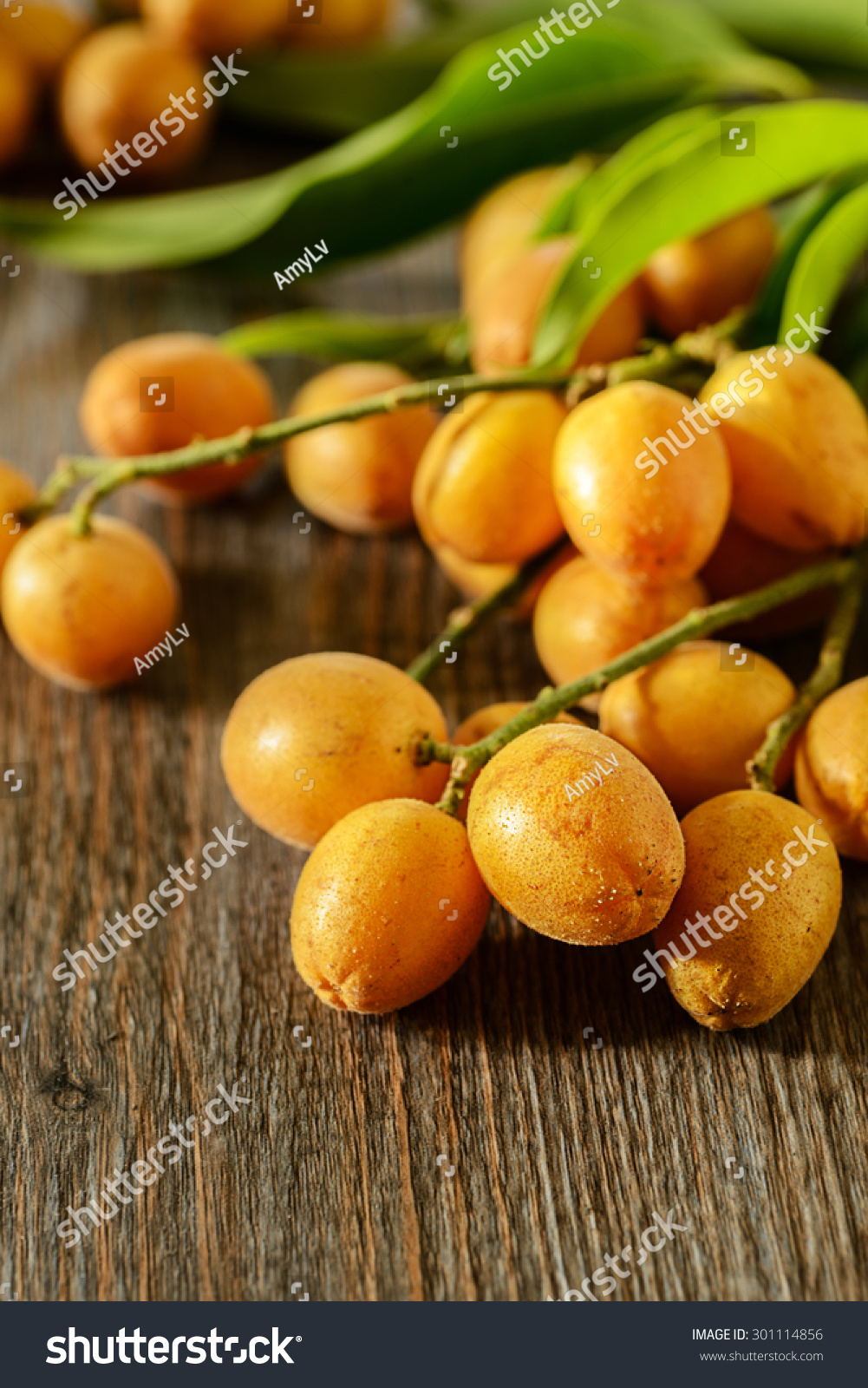 fresh wampee fruit on the wooden board
