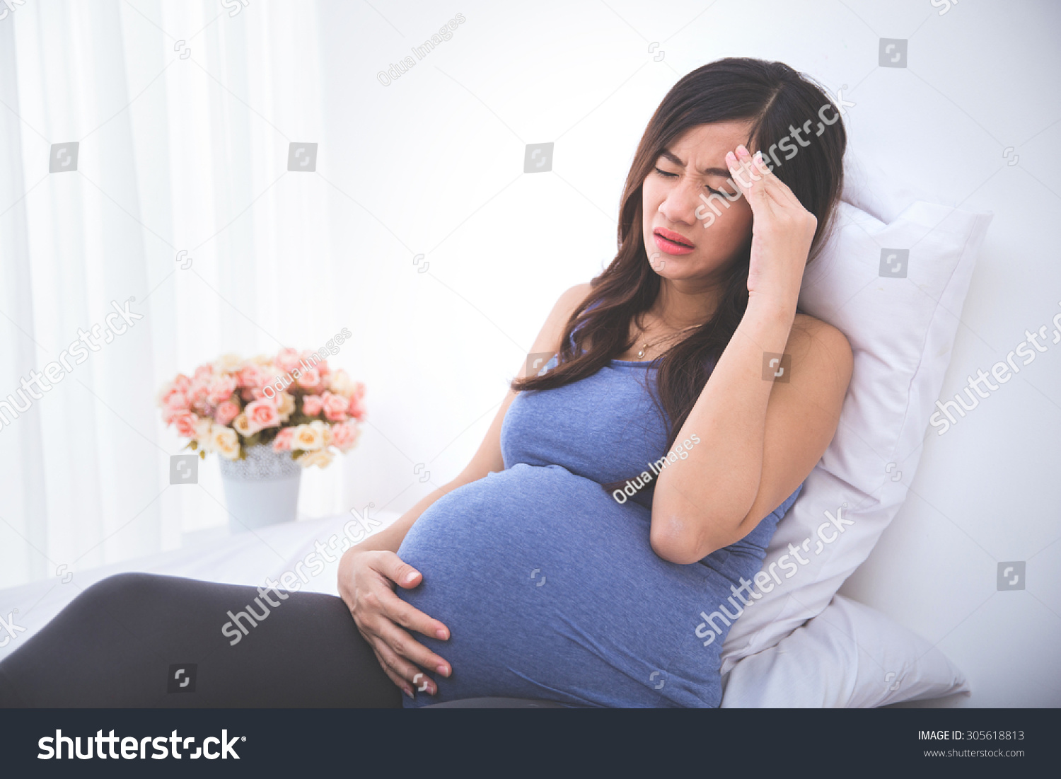 pregnant woman having a headache and morning sickness