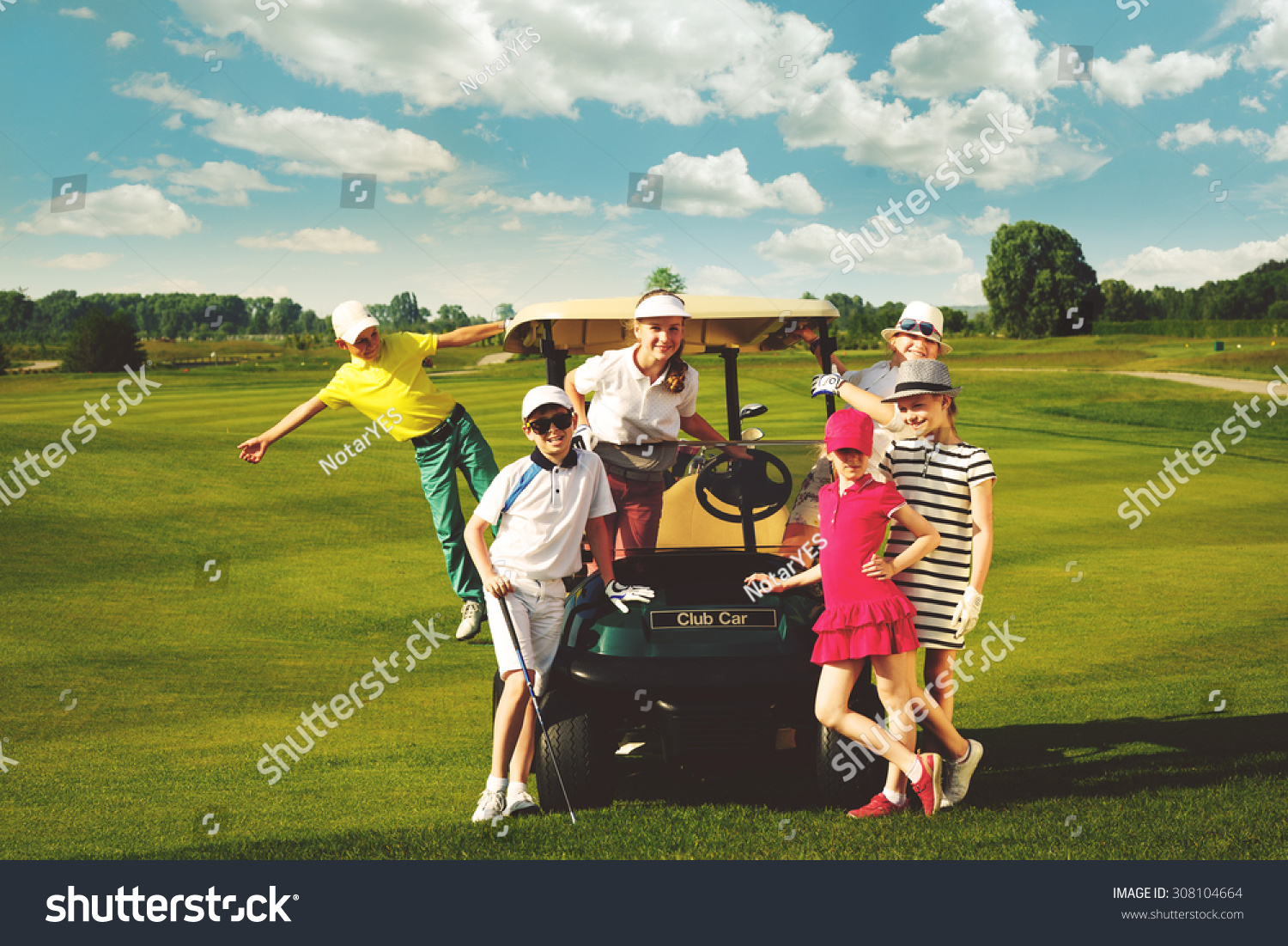 Children posing near golf car at golf course at summer day