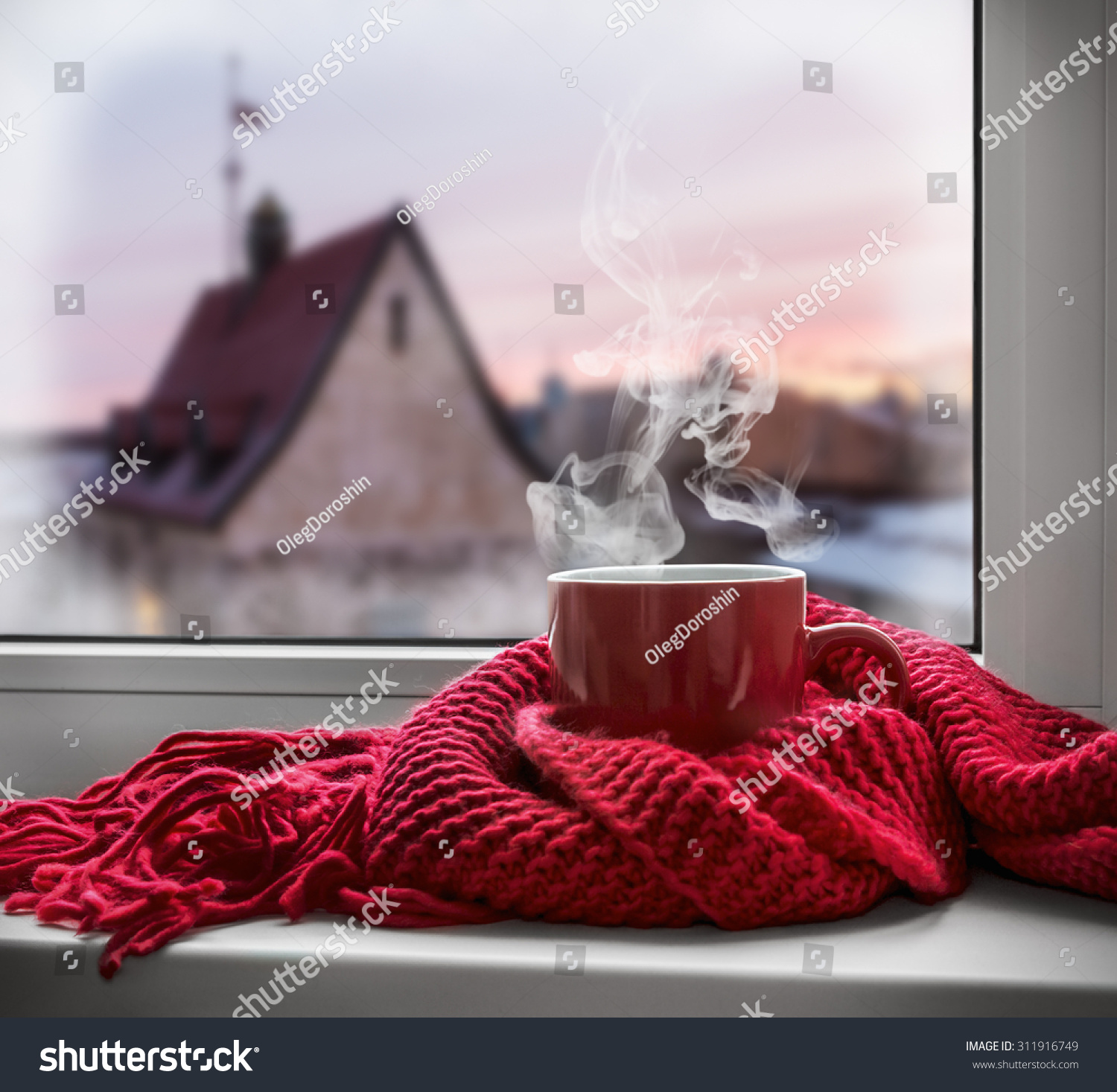 cup with a hot drink on the windowsill in the background of a winter city. Focus on the edge of the cup