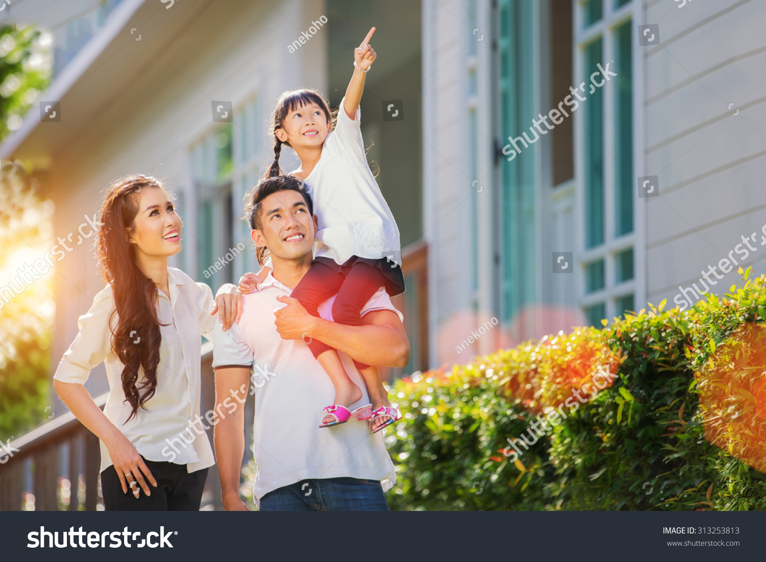 Beautiful family portrait smiling outside their new house with sunset 