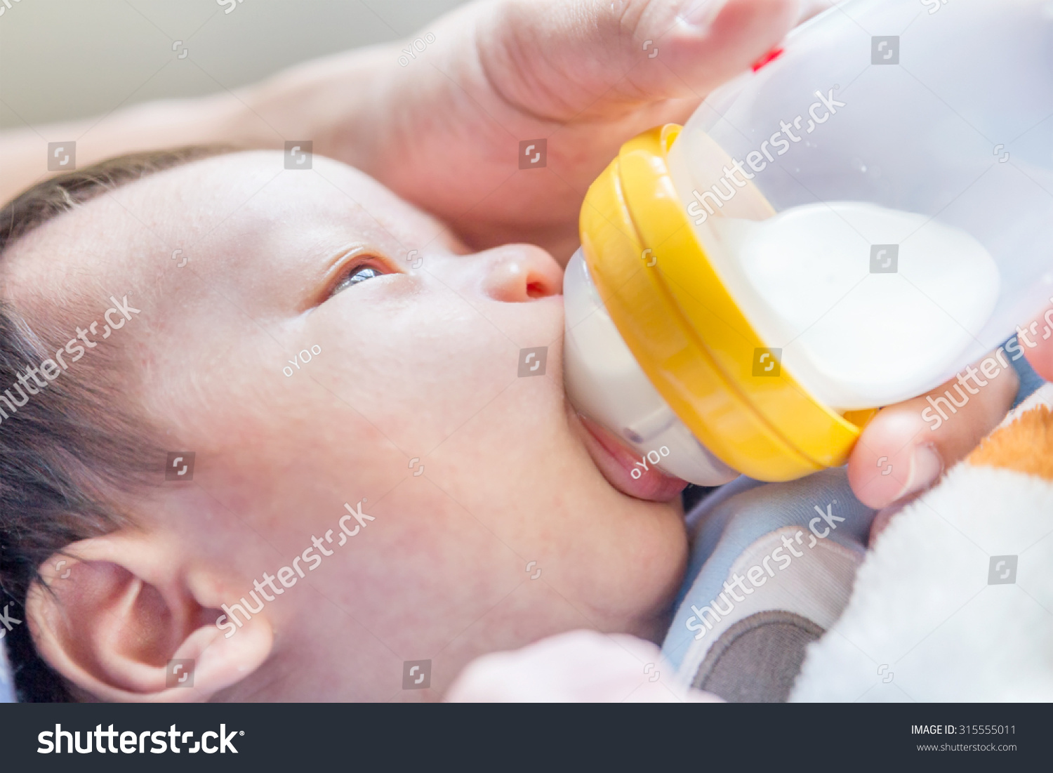 Portrait of a newborn drinking milk from a baby bottle 
