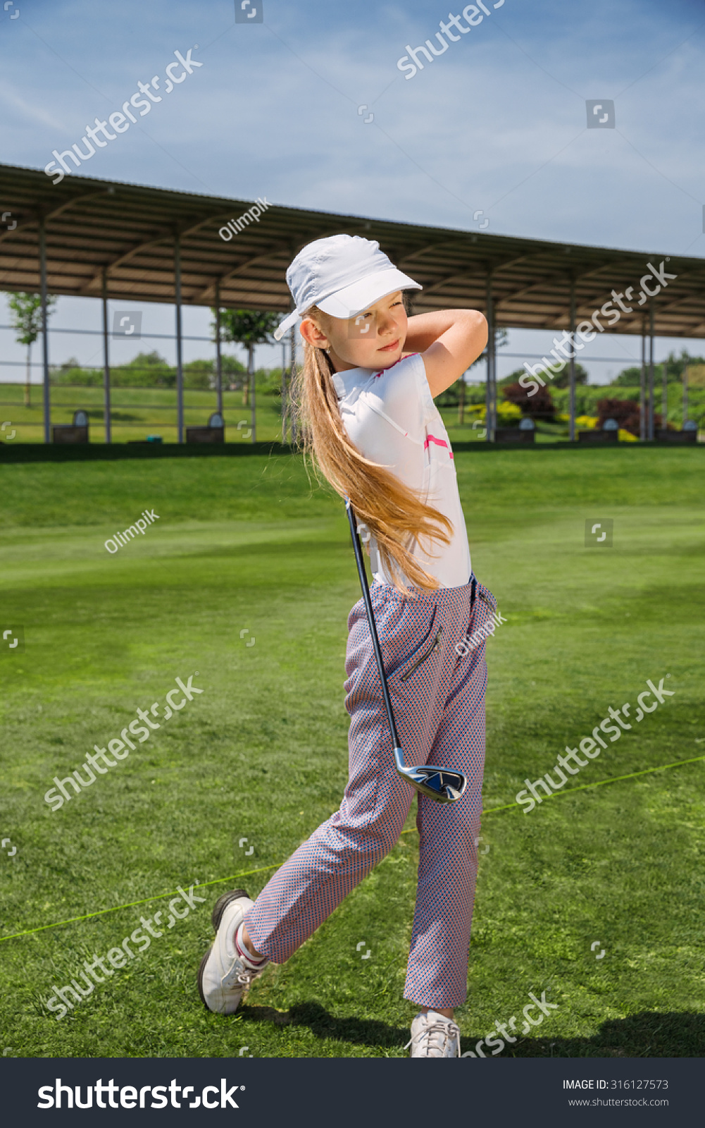 Girl golf player practicing in golf school