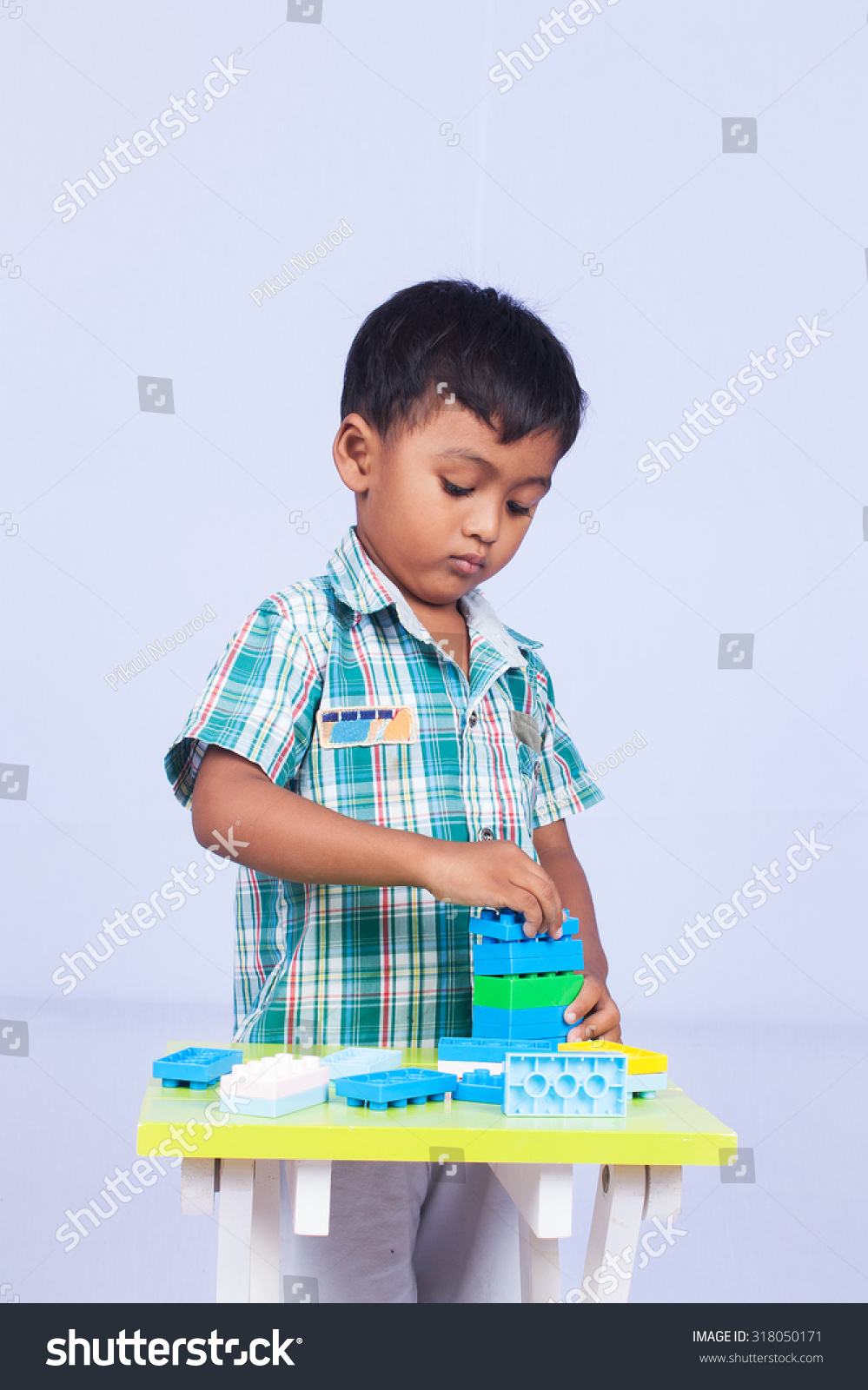 a little asian boy play building brick on white background