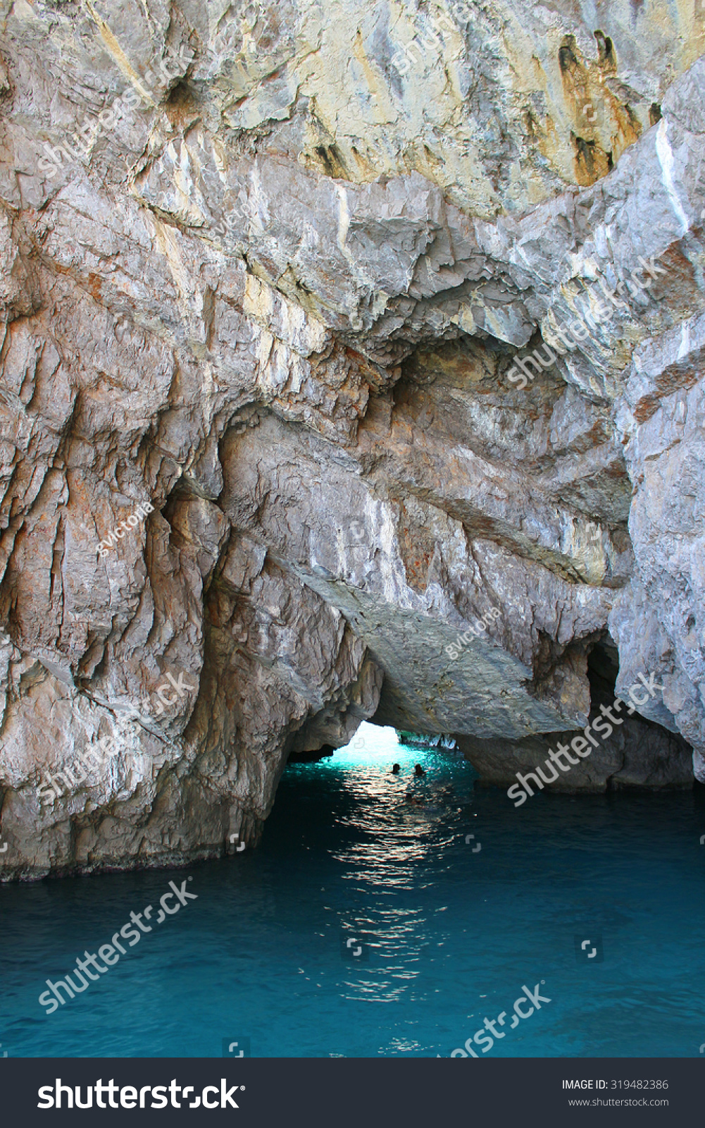 People swimming in a grotto in Capri with crystal blue water