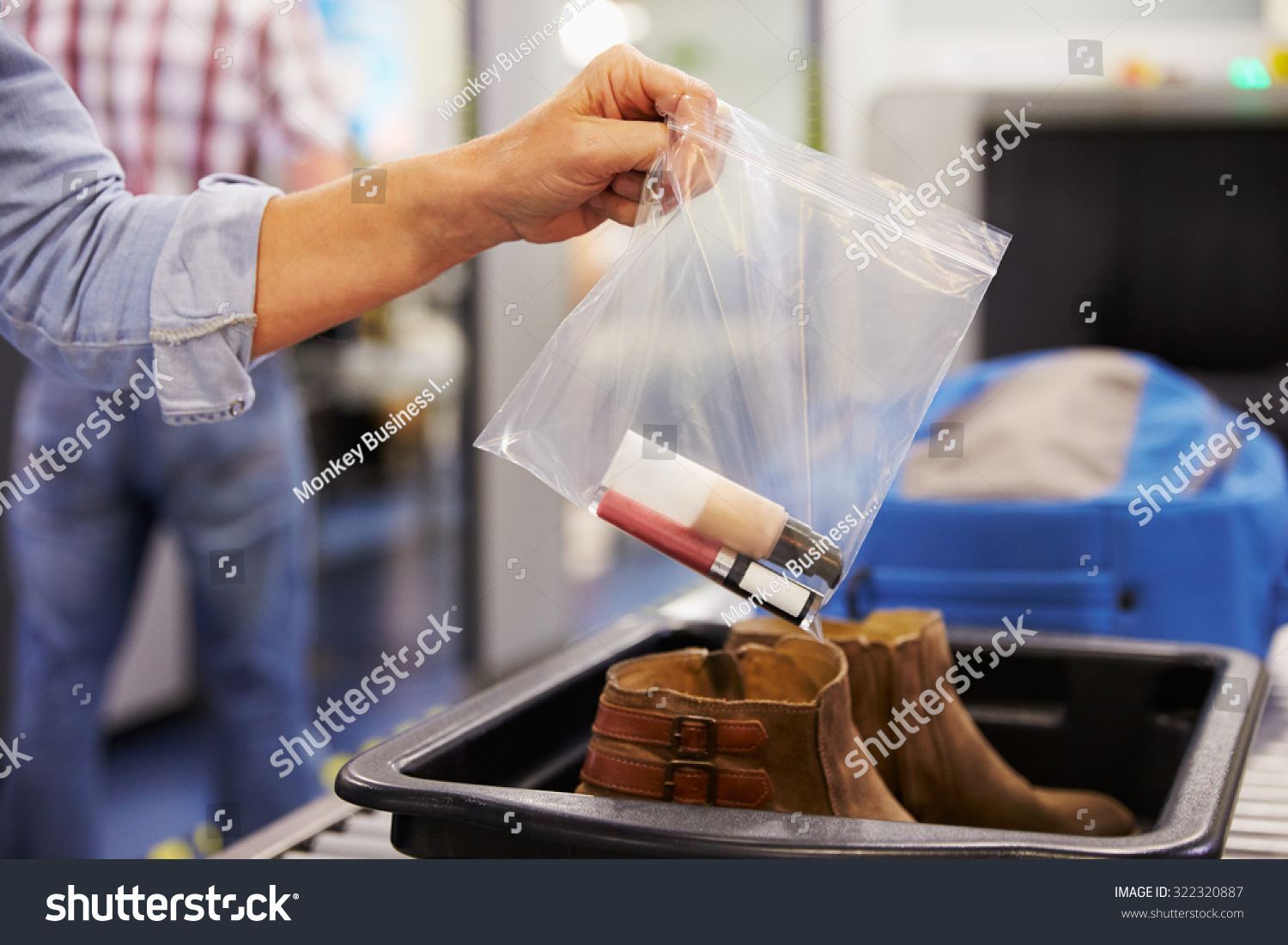 Passenger Puts Liquids Into Bag At Airport Security Check