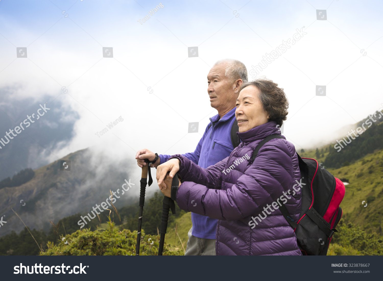 happy asian senior couple hiking on the mountain