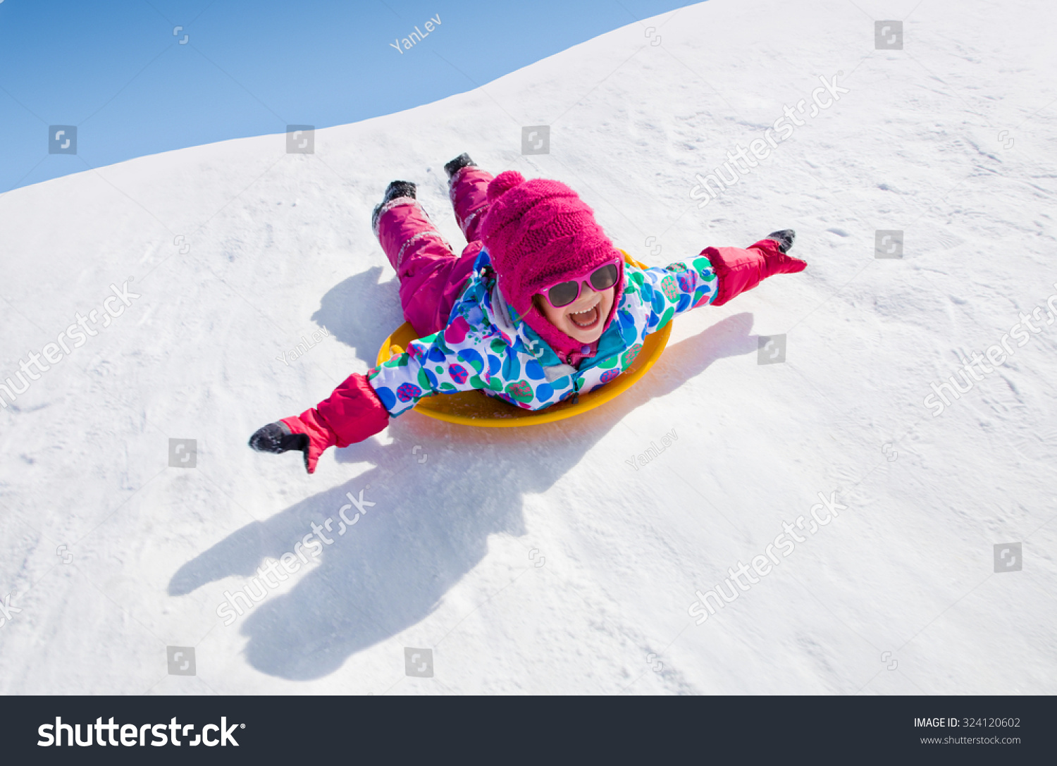 little girl riding on snow slides in winter time
