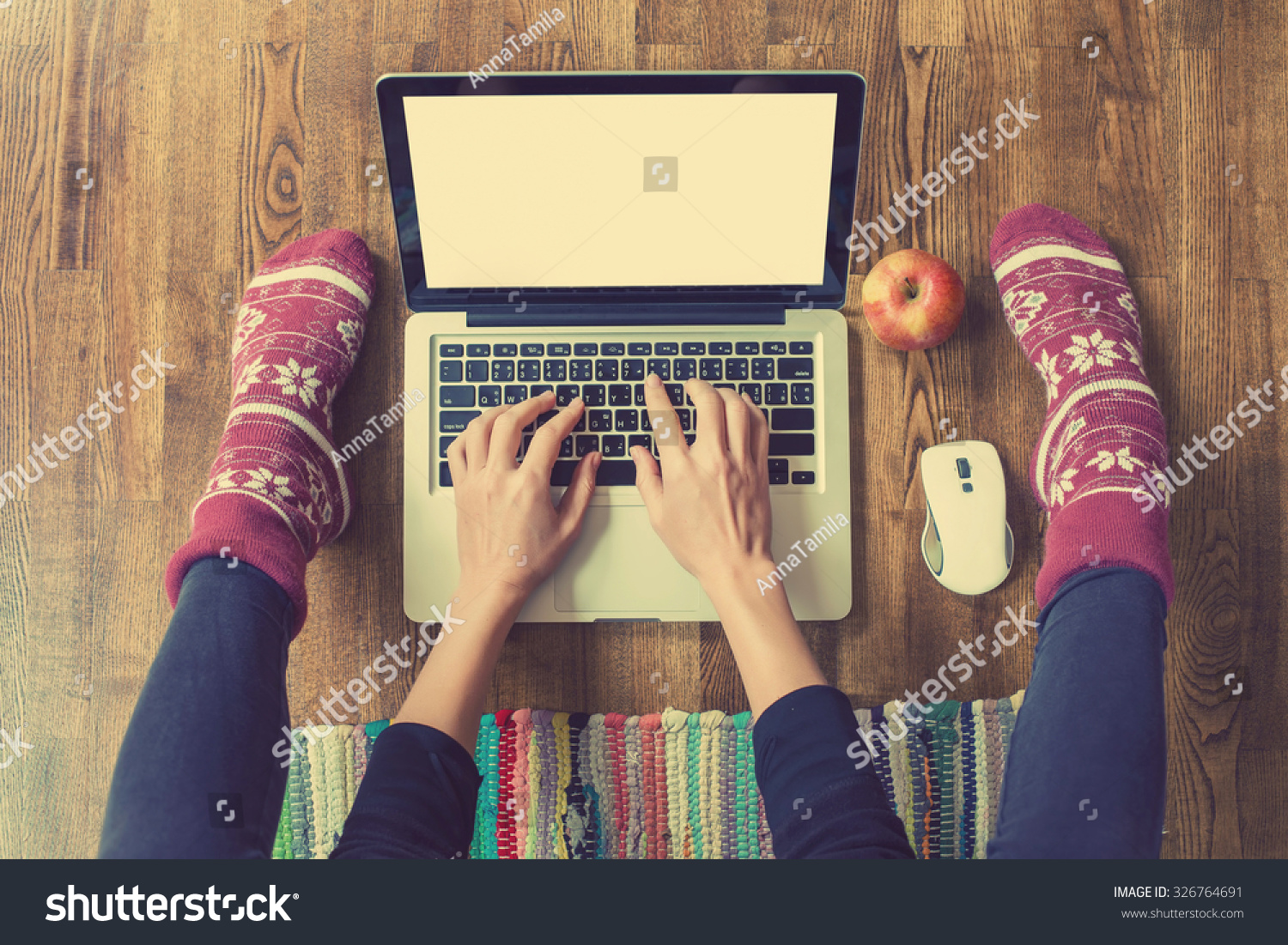 Woman's hands typing on laptop keyboard. Study and work online freelance warm socks winter home comfort and relax