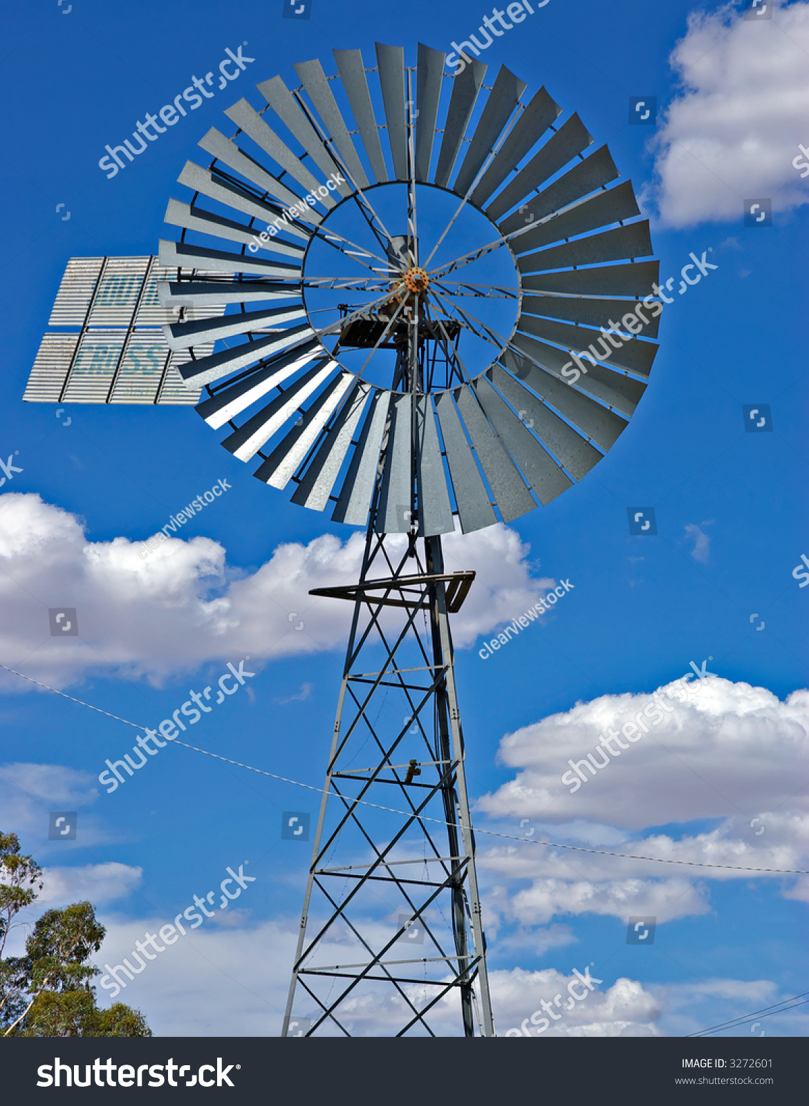 abigsilvermetalwindmillinfrontofanicecloudybluesky