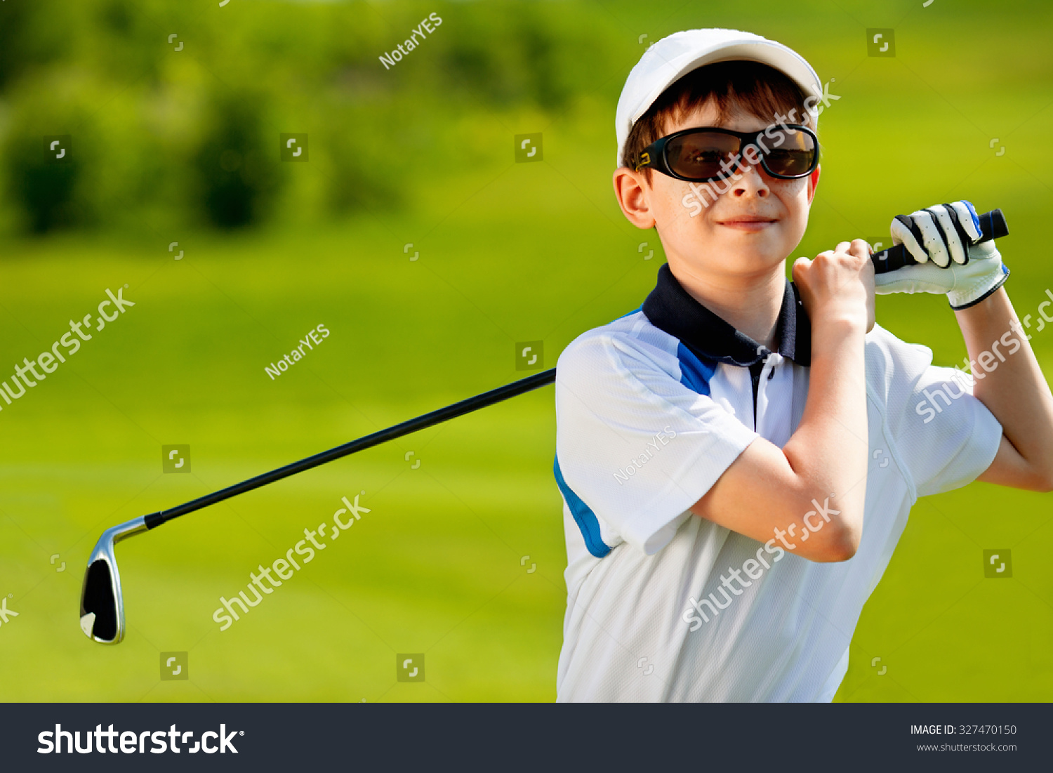Portrait of boy golfer in golf course at summer day