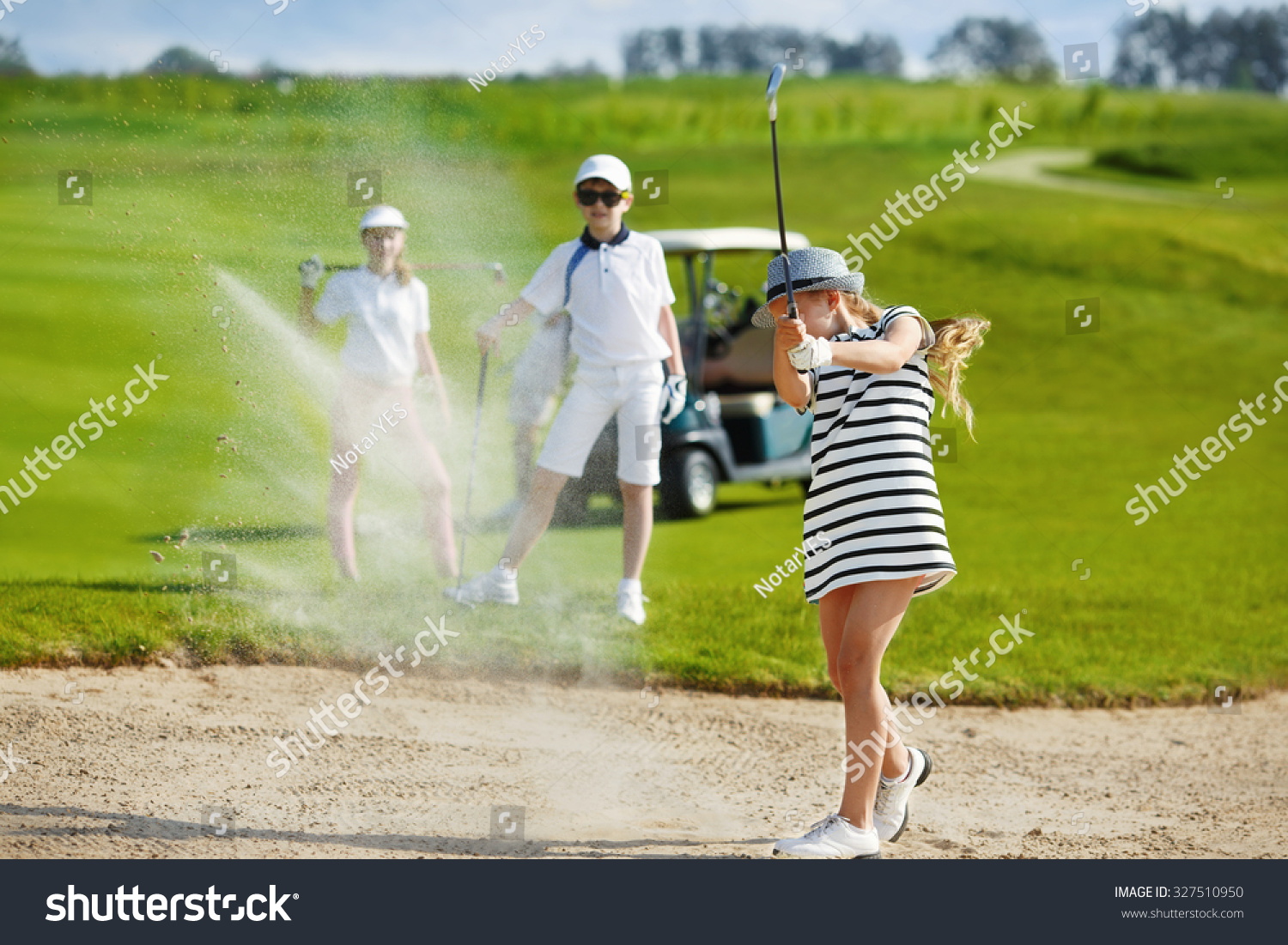 Girl playing golf and  hitting from bunker 
