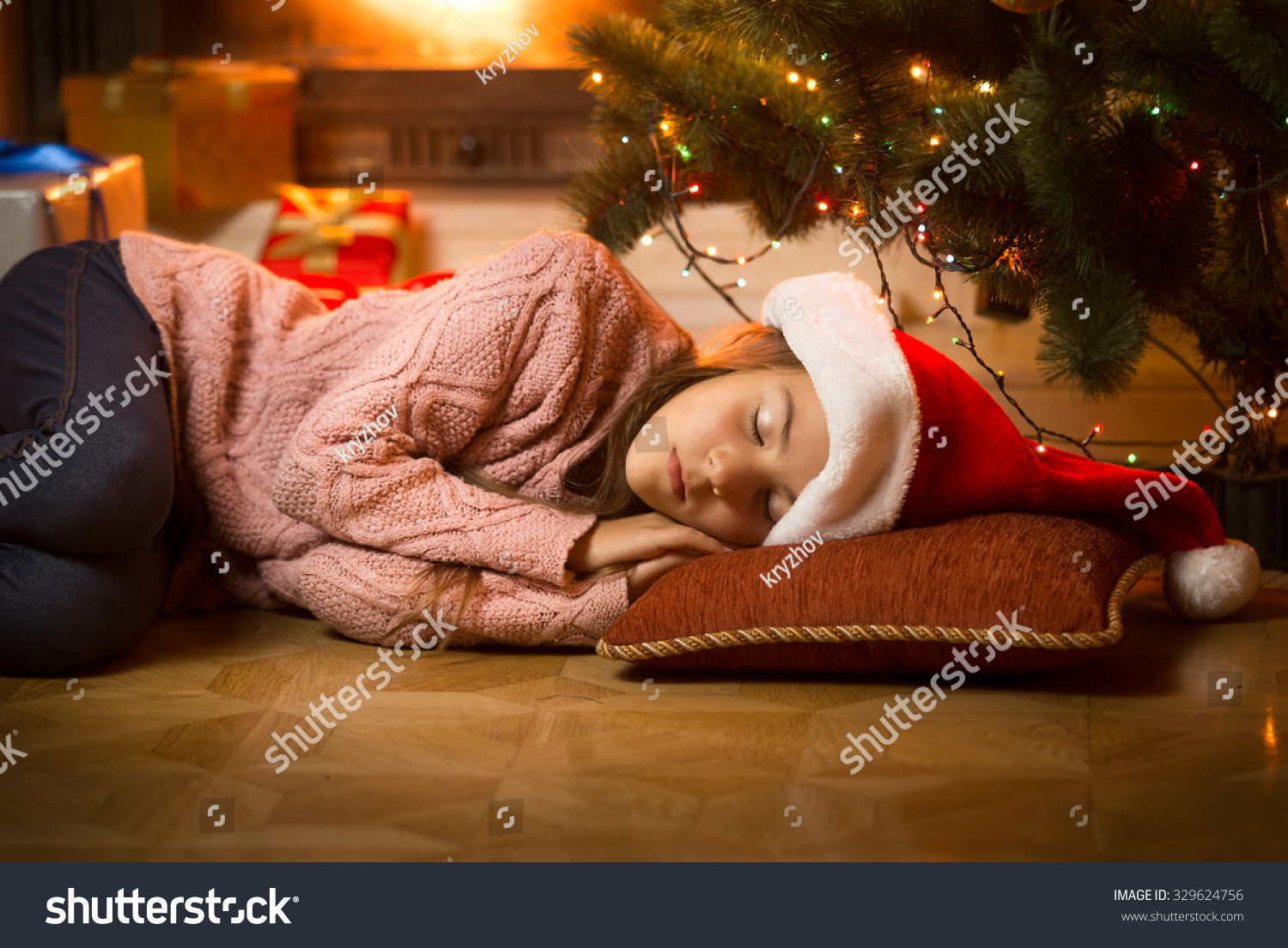 littlegirlsleepingonflooratfireplaceunderchristmastree