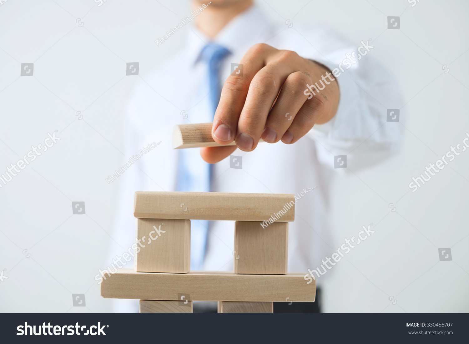 Close up of businessman building tower of wooden blocks