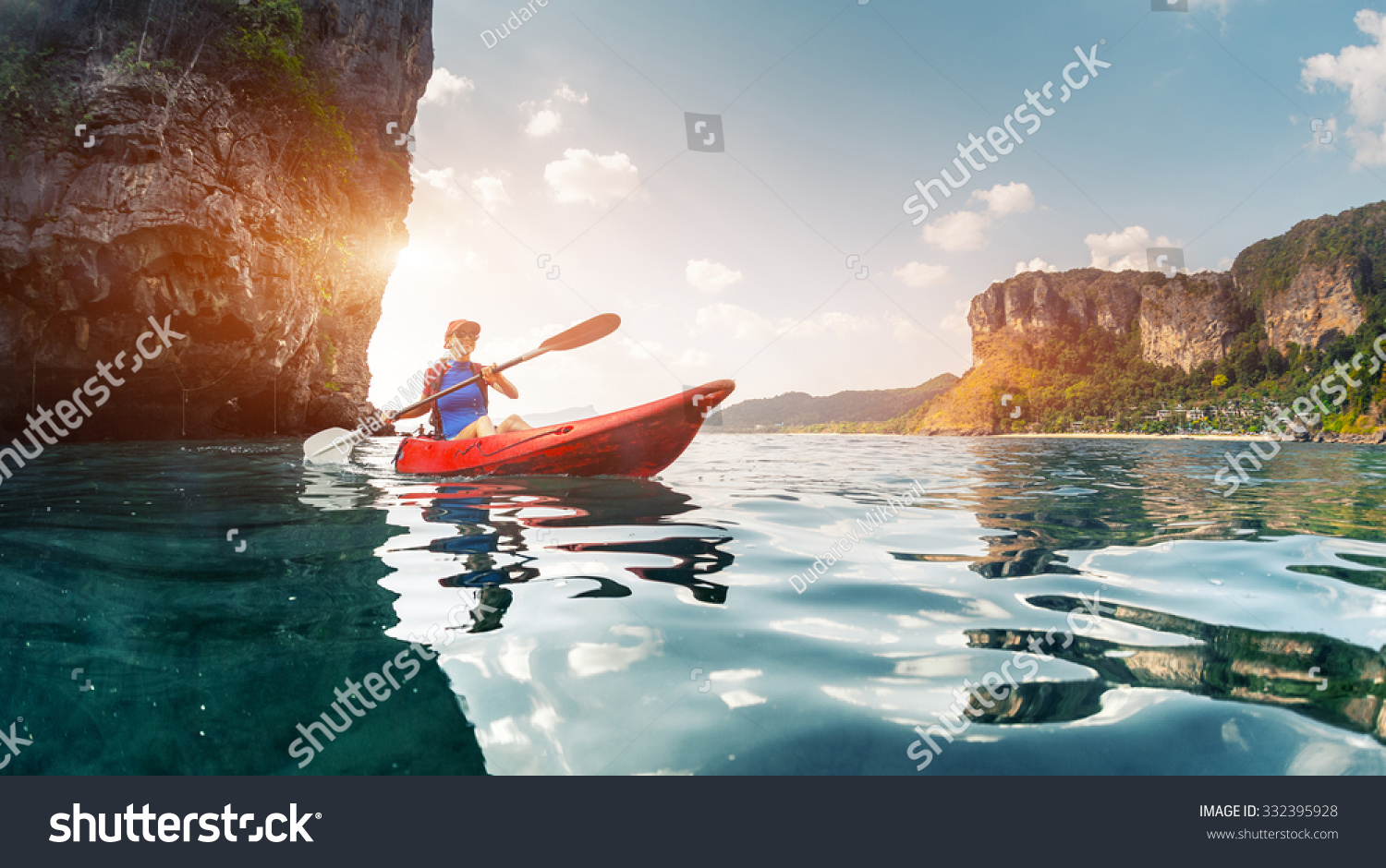 Lady paddling the kayak in the calm tropical bay