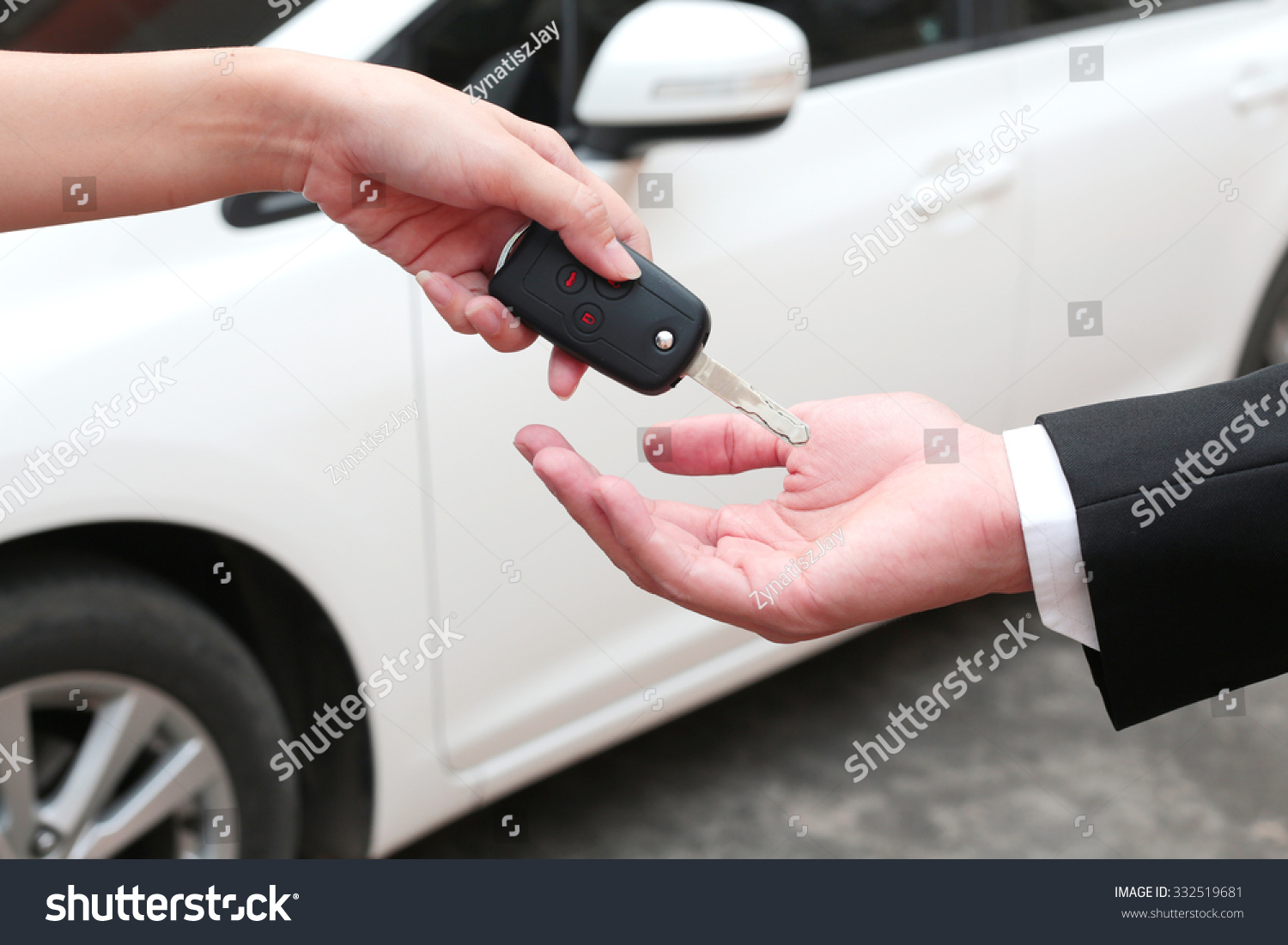 Female hand giving a key for buyer or rental car.