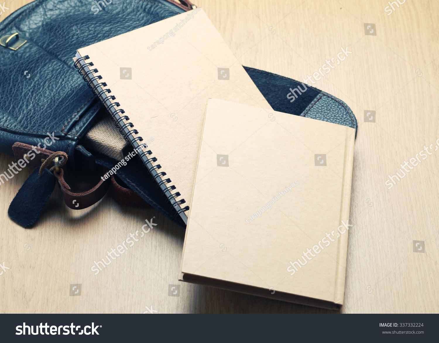 Notebook with leather bag on desk- vintage filter.
