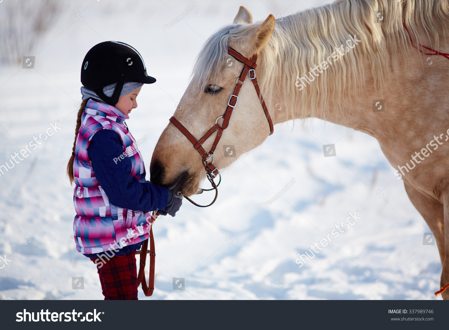 Little girl with horse outdoor in winter