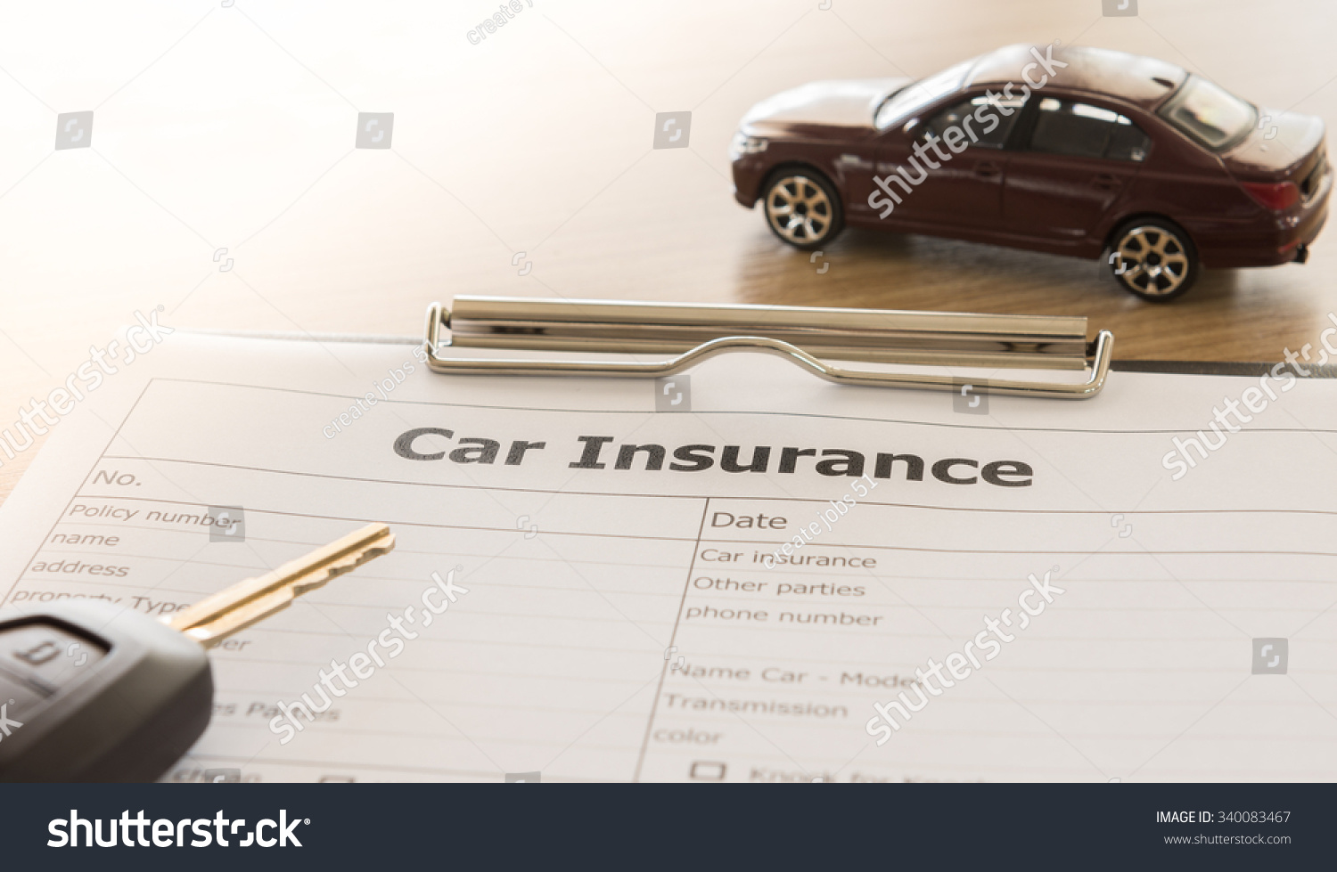 car insurance application form with car model and key remote on desk.