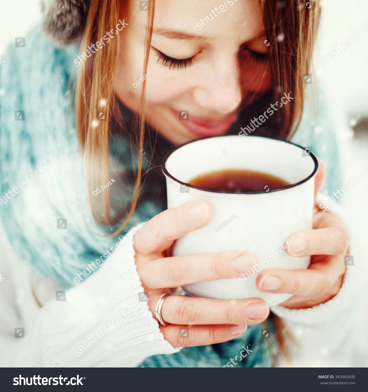 Young Beautiful Female Drinking Hot Drink Outdoors in Winter. Close Up Headshot. Drawn Snow. Selective Focus. Instagram color effect.