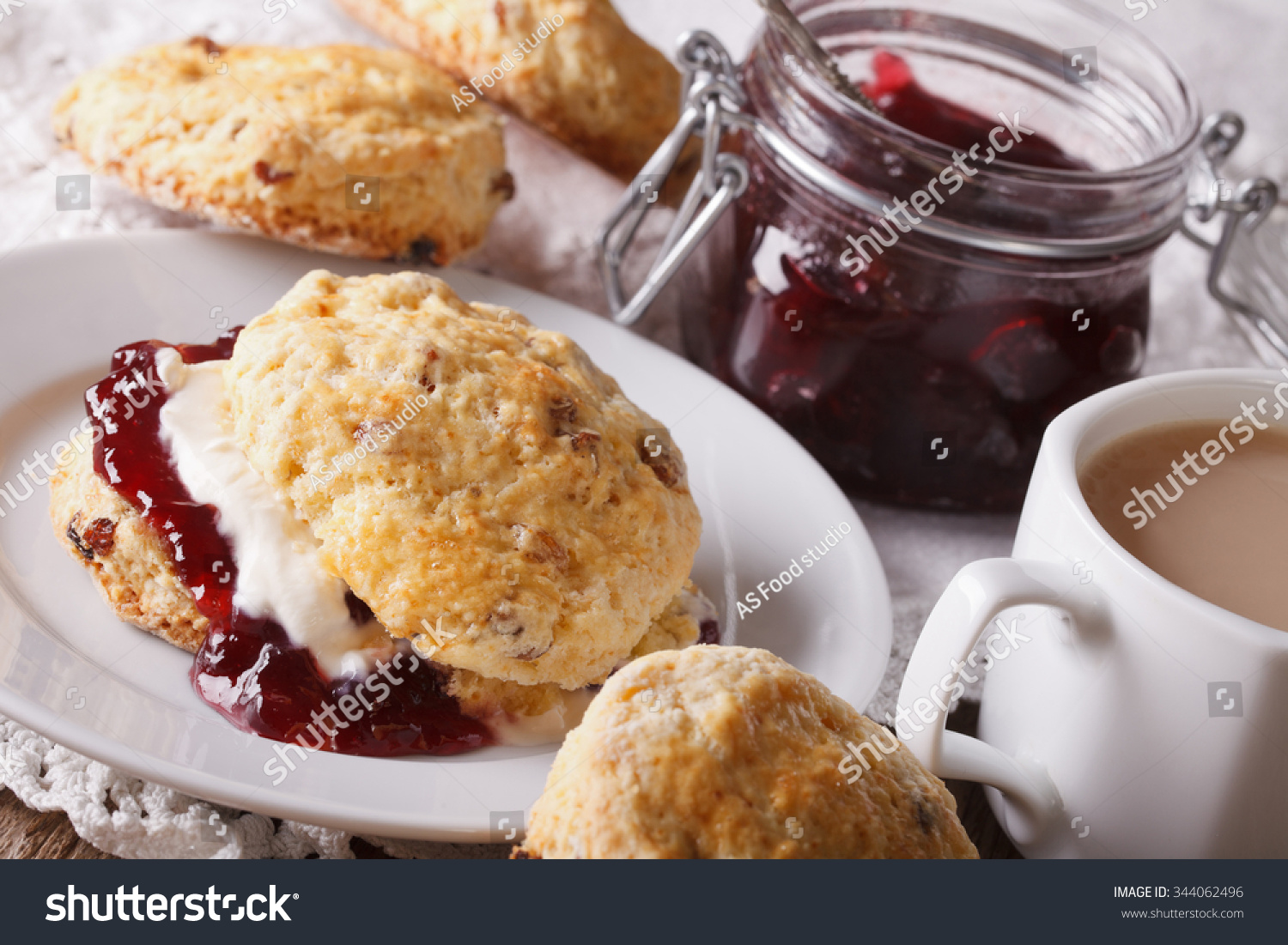 English pastries: scones with jam and tea with milk close-up on the table. Horizontal