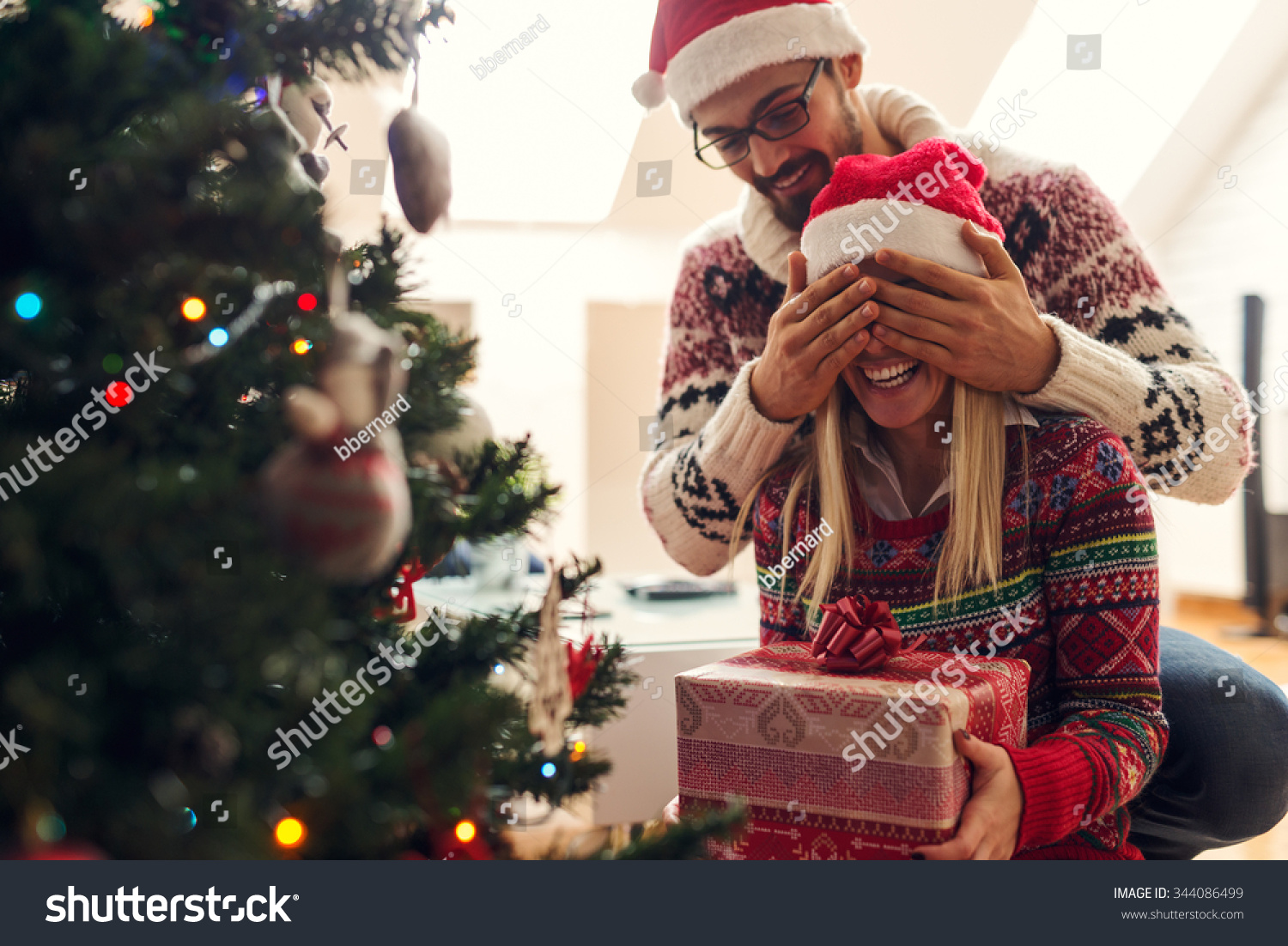  Cropped shot of a man surprising his girlfriend with a Christmas gift.