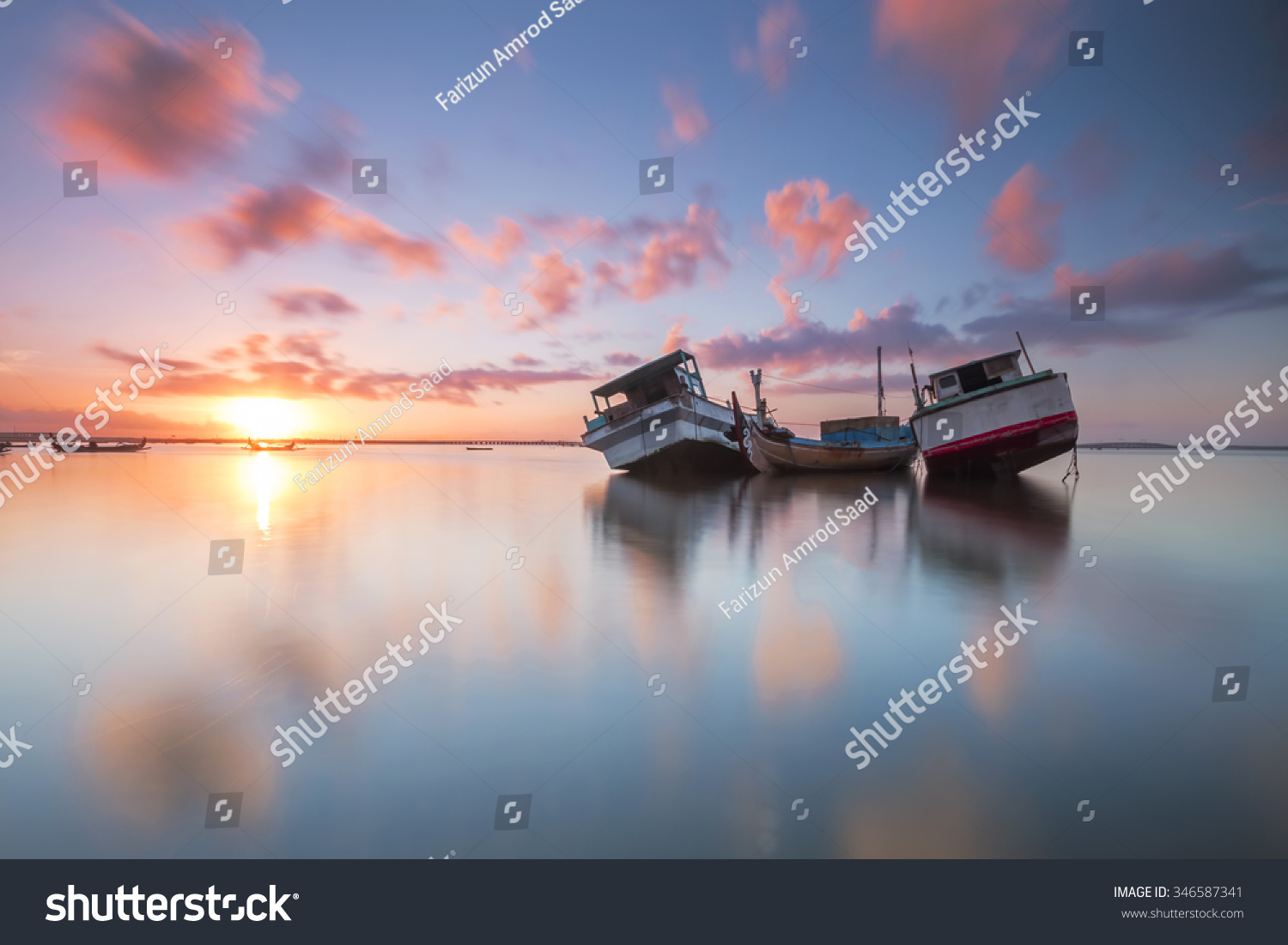 Sunrise at Tuban Beach Bali with traditional balinese fishing boat. Motion sky long exposure.