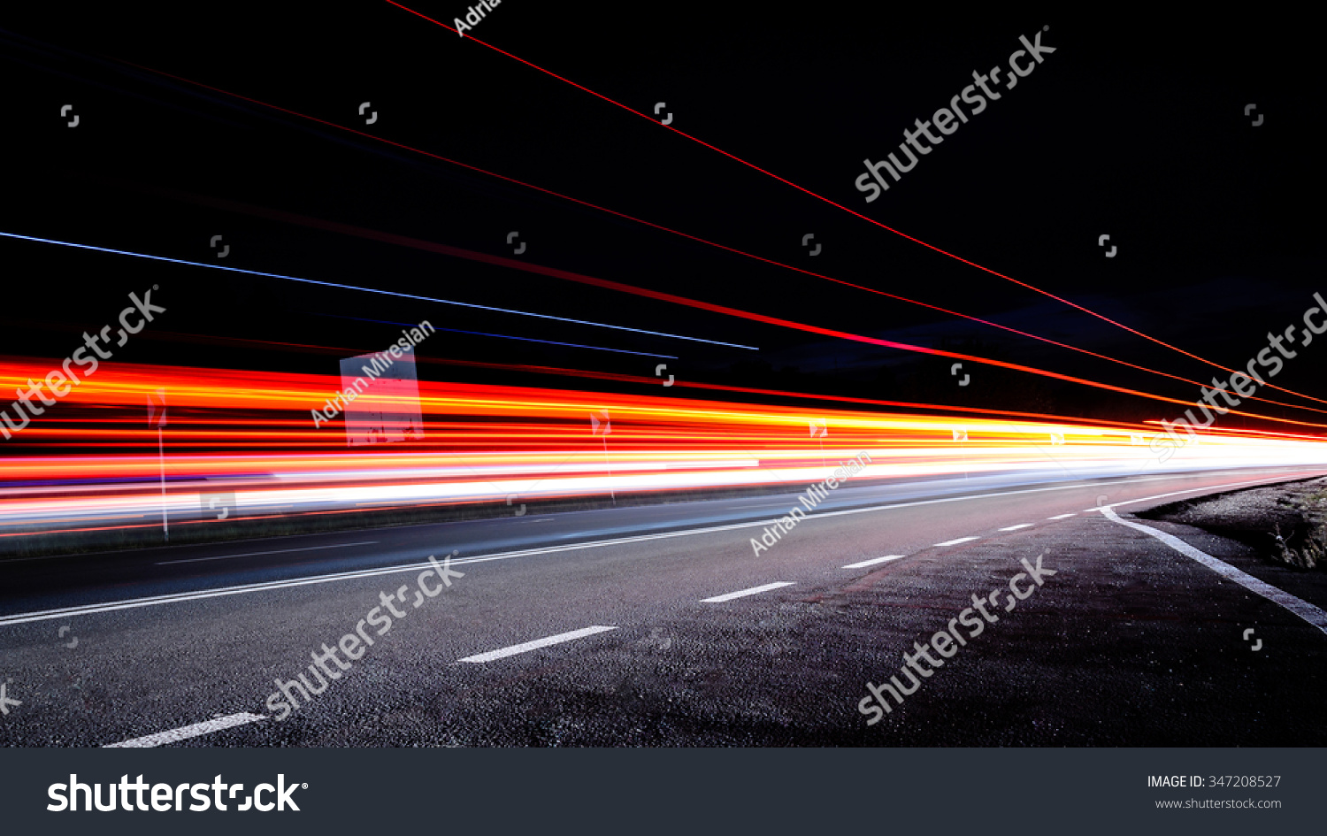 Three red lines / red light trails at night on the road