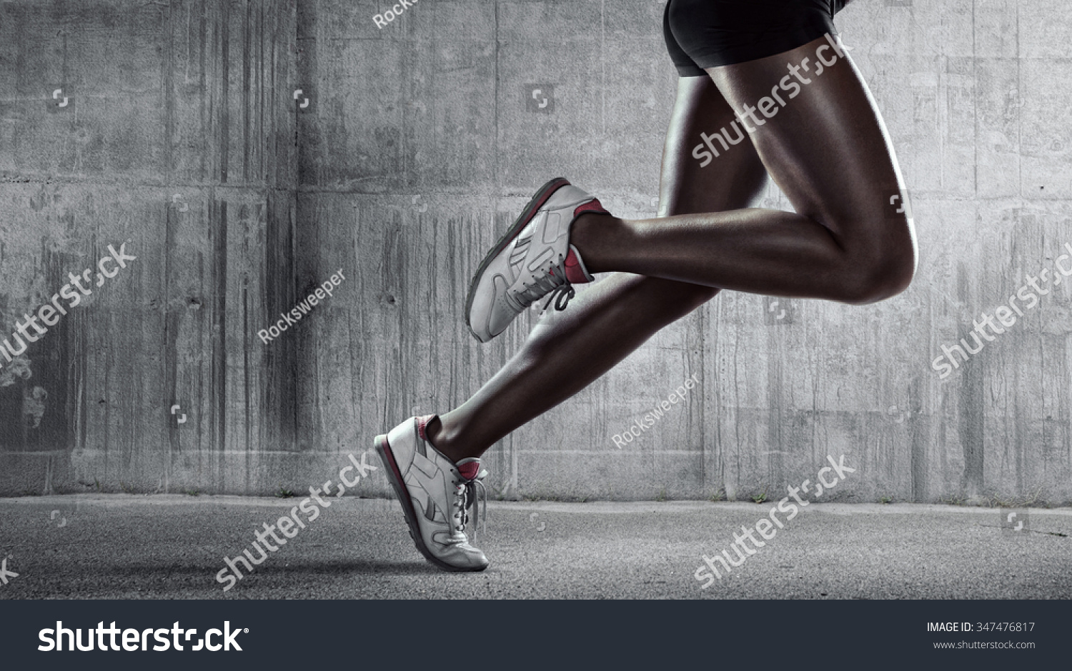 Sports background. Runner. Side view of a jogger legs on concrete wall