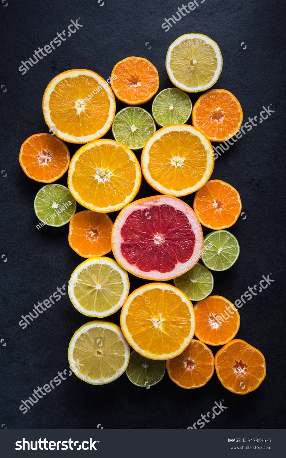 Citrus half cut fruits on dark background  from above