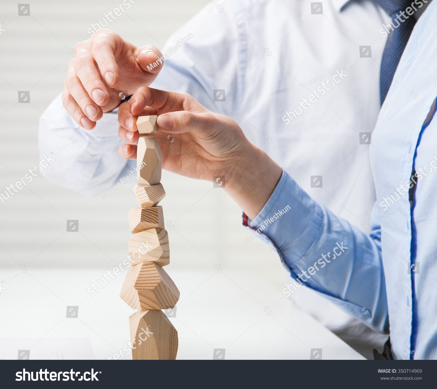Business people building wooden tower (Japanese game tumi-ishi)  illustrating concept of business success  cooperation  achievement and self-control