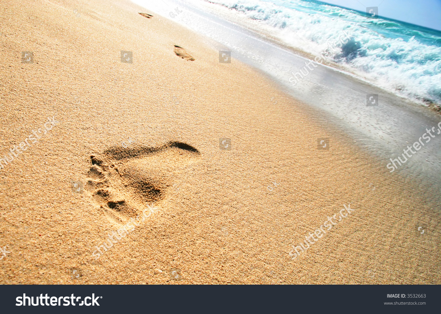 Foot Prints on Tropical Sandy Beach and sea waves in the background