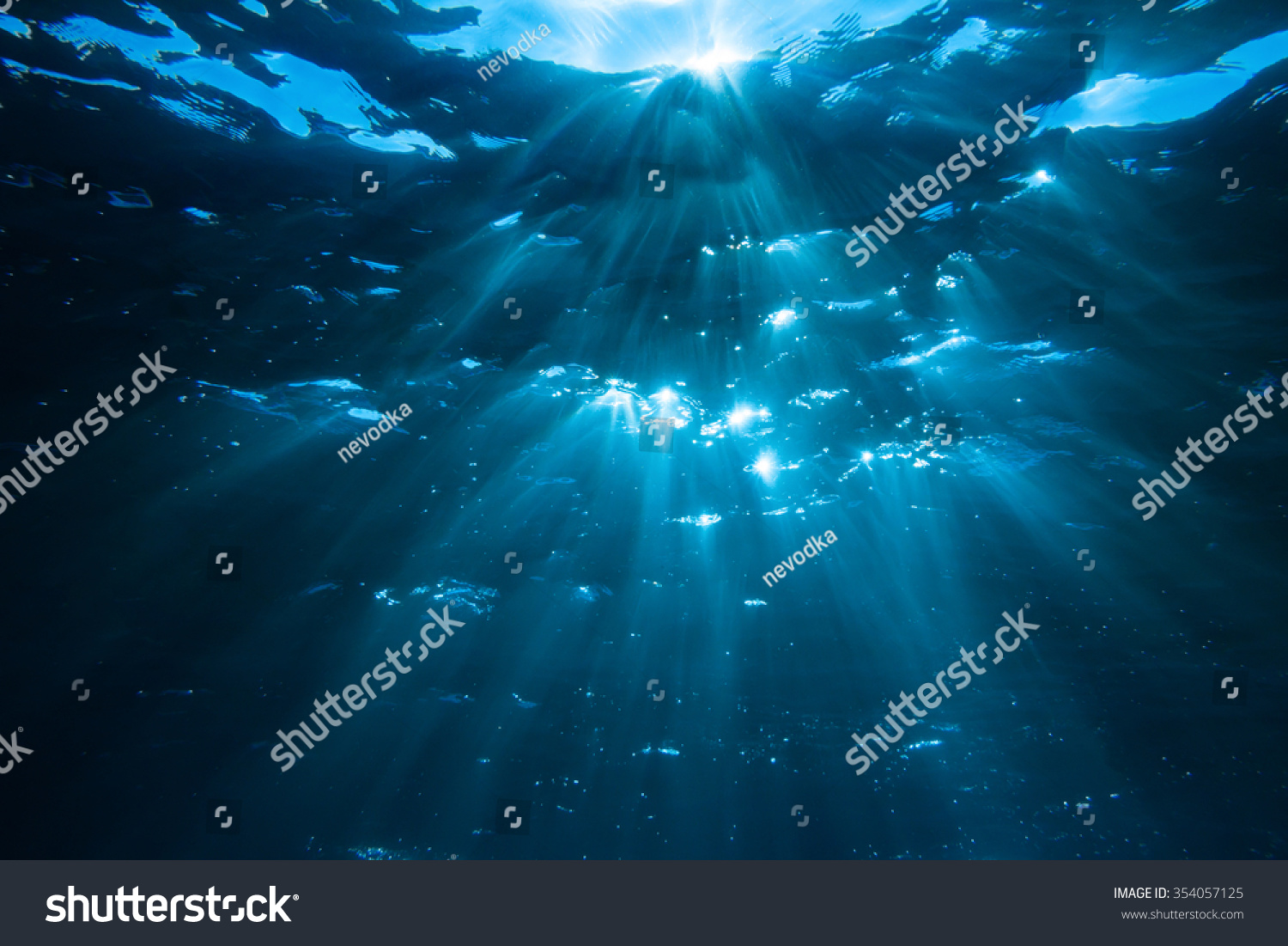 Underwater shot with sun rays in deep blue tropical sea