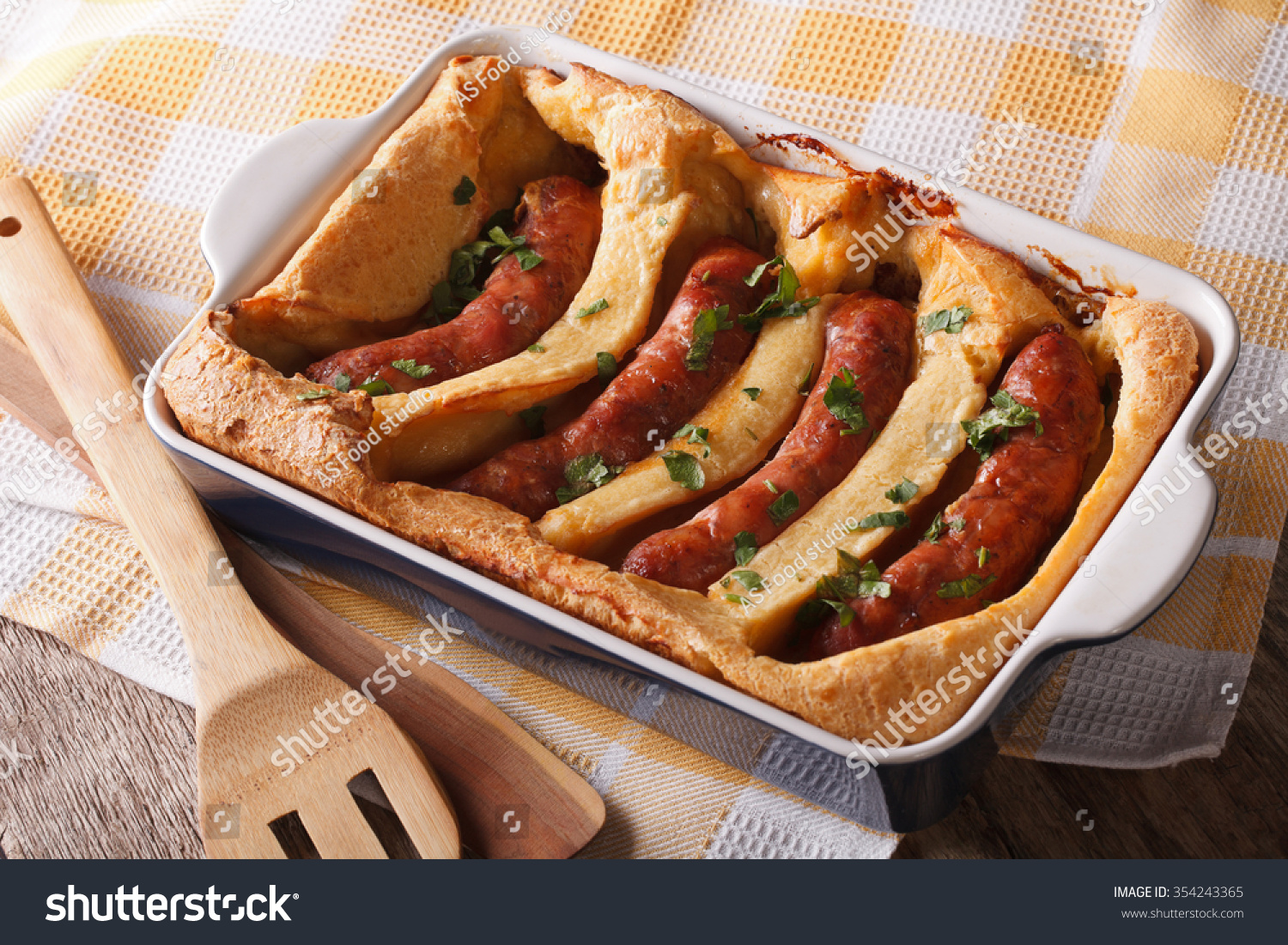 English food: toad in the hole into a baking dish close up on the table. Horizontal