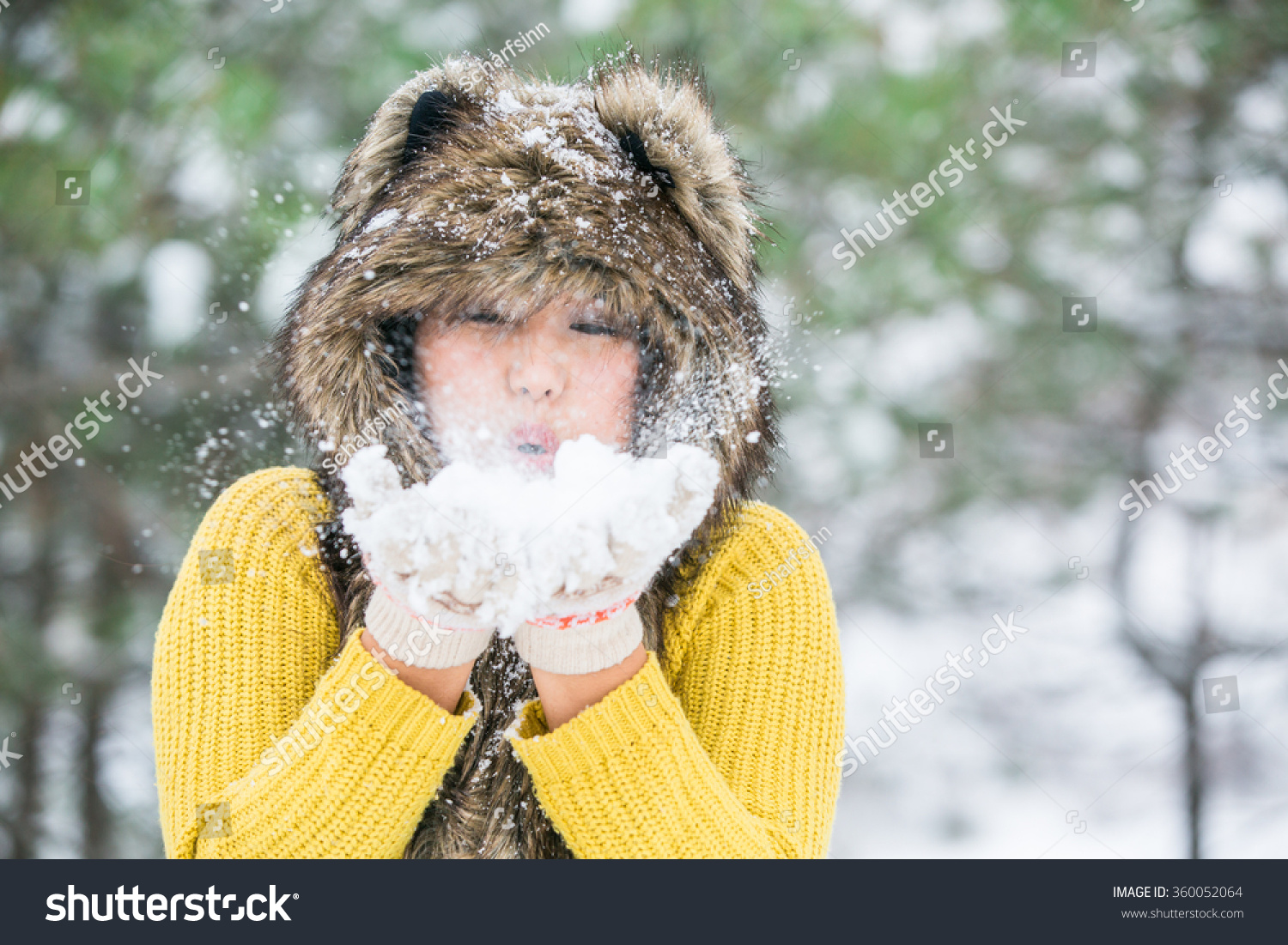 Asian girl in a fur hat from the hide of a wolf.