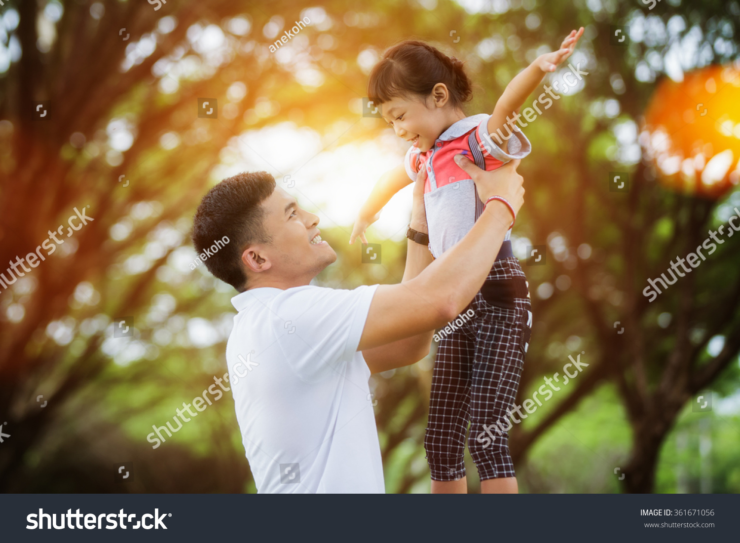 Portrait of little girl hugging her daddy with nature and sunlight  family concept