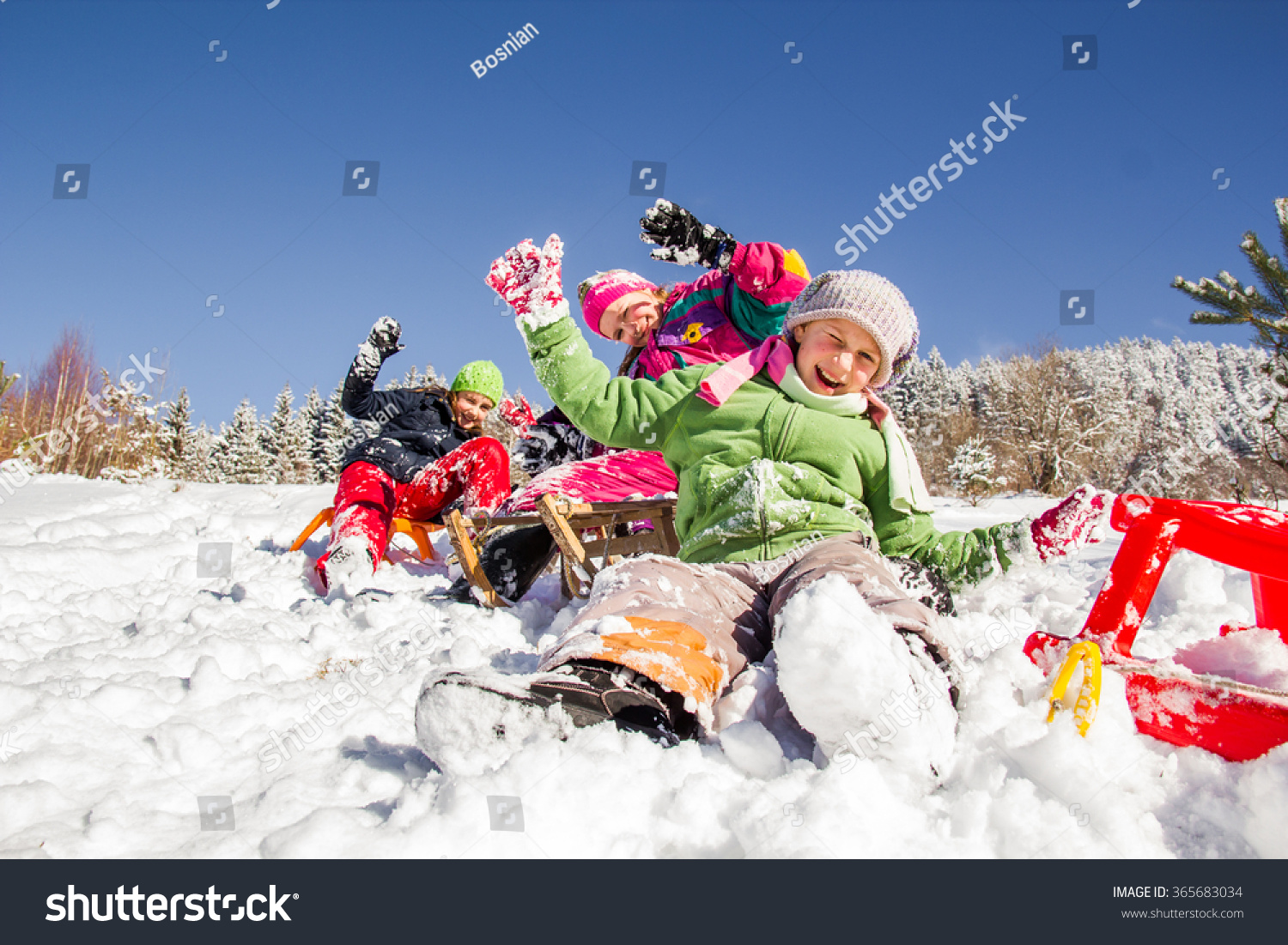 Happy children sledding at winter time. Group of children spending a nice time in winter.